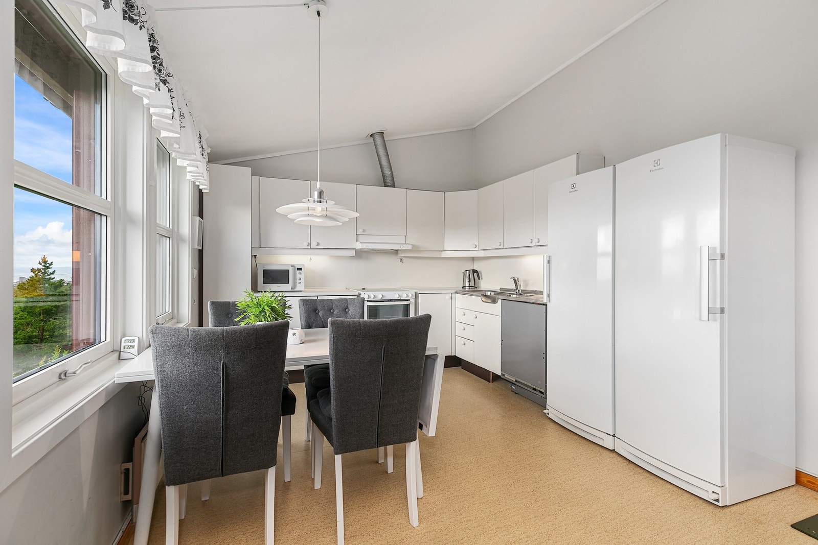 Romslig, åpent kjøkken med store vinduer. Galleribilde