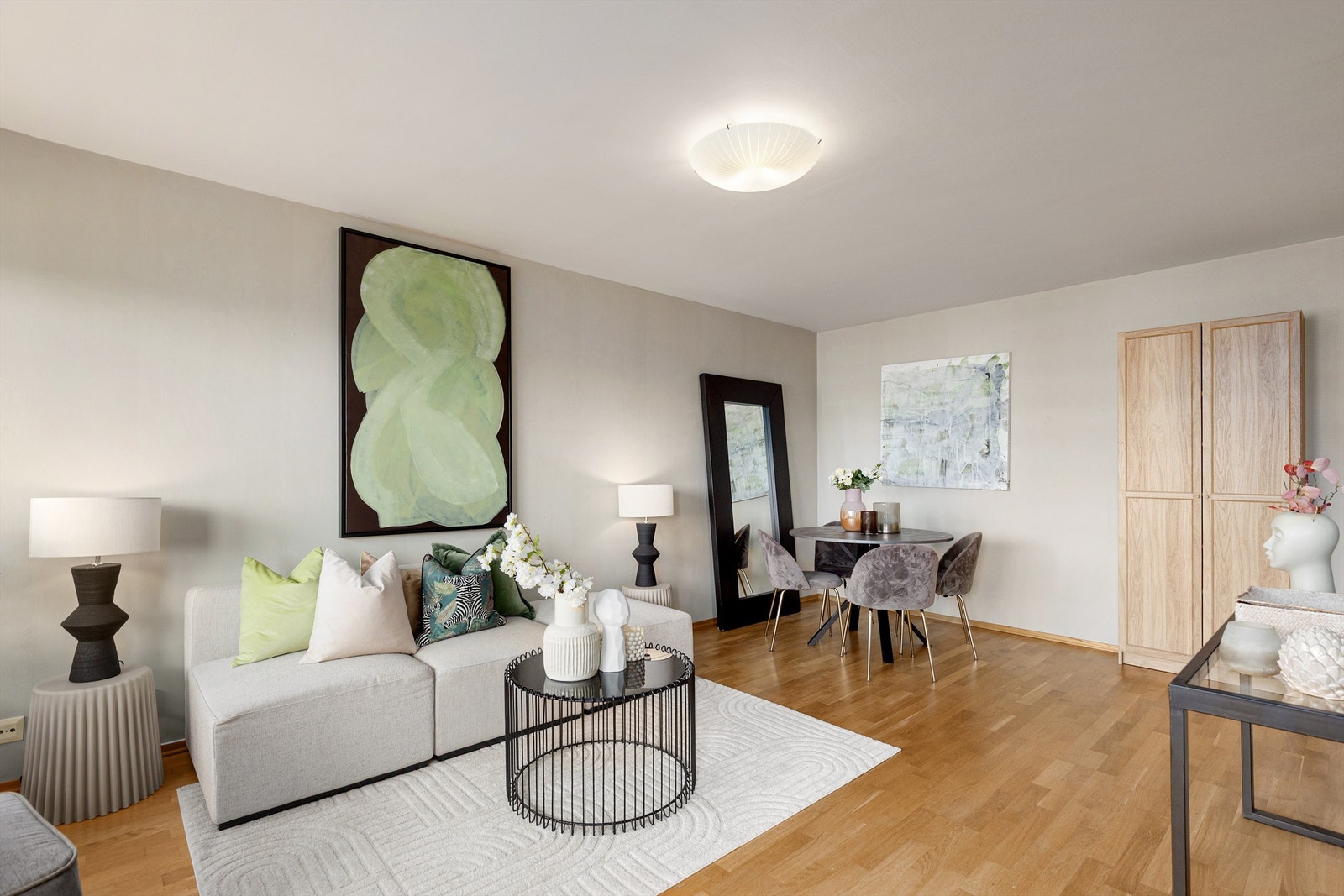 Romslig stue med god plass til både sofagruppe med stuebord og TV-benk på den ene siden, samt spisebord og vitrineskap på motsatt side Galleribilde