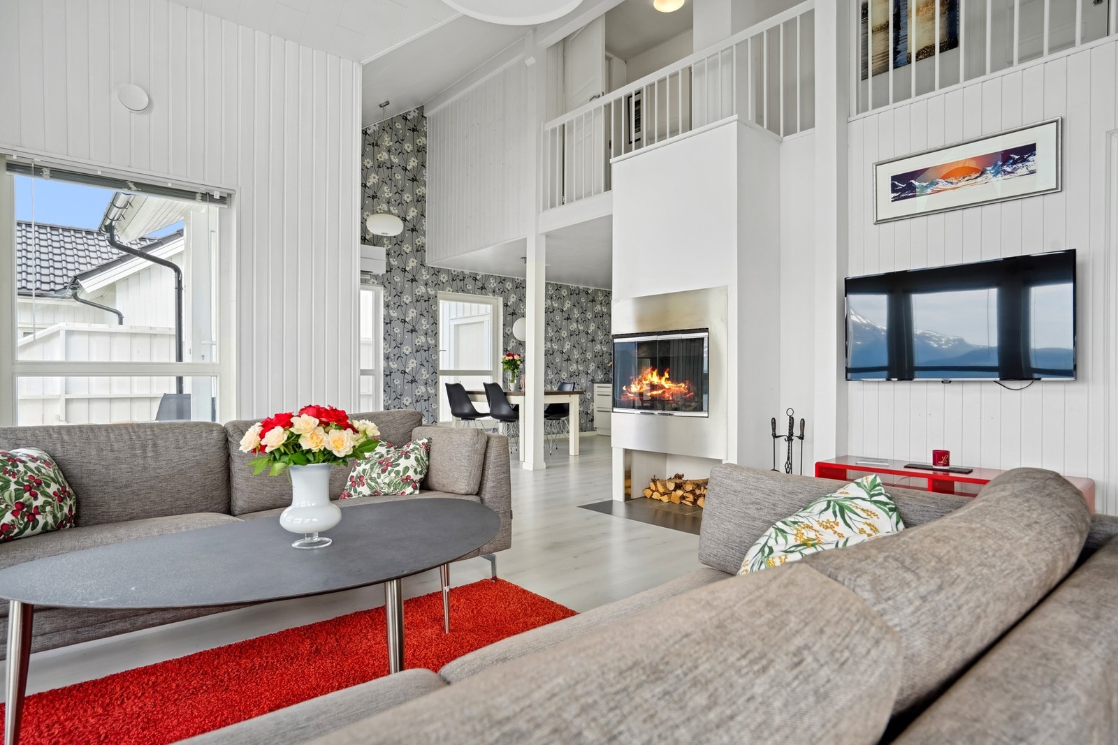 Romslig stue med lyse farger og vedfyring. Galleribilde