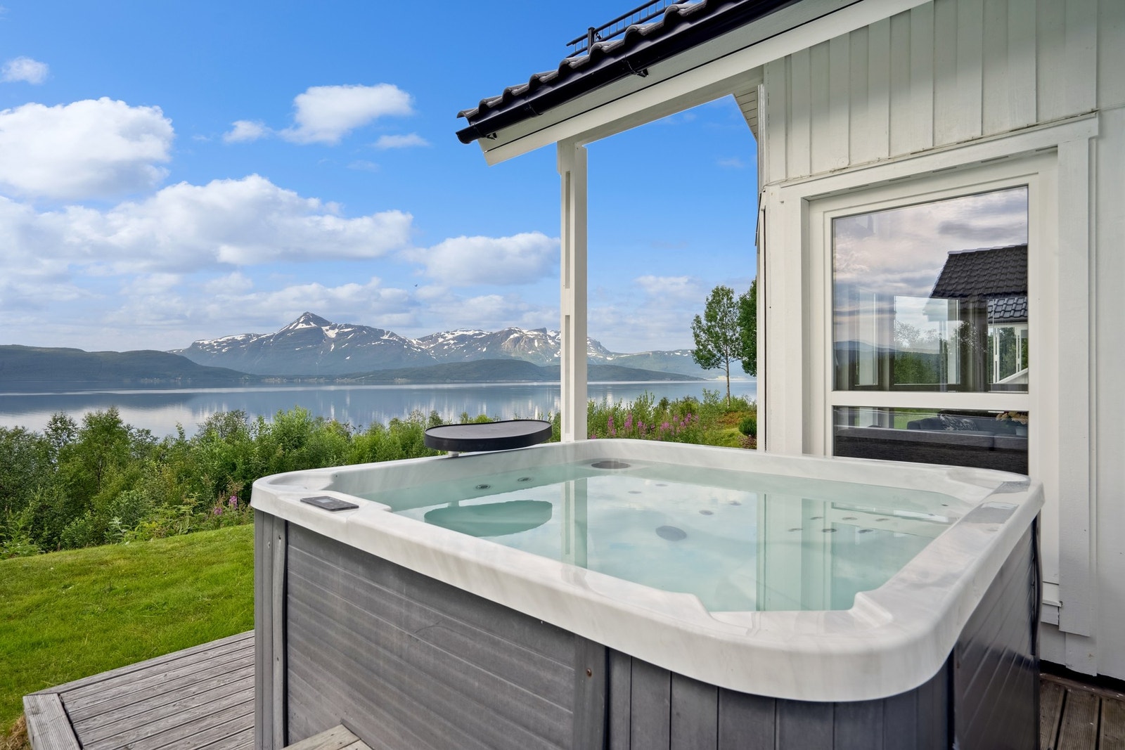 Jacuzzi på romslig platting hvor du kan nyte utsikten mot fjorden og omkringliggende fjell. Galleribilde