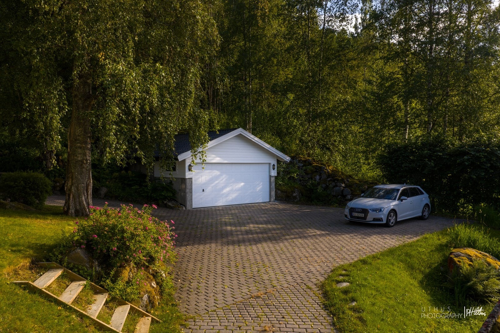 Frittstående garasje med dobbel leddport fra 2000. Privat vei til eiendommen på ca. 50 meter fra Fylkesveien. Galleribilde