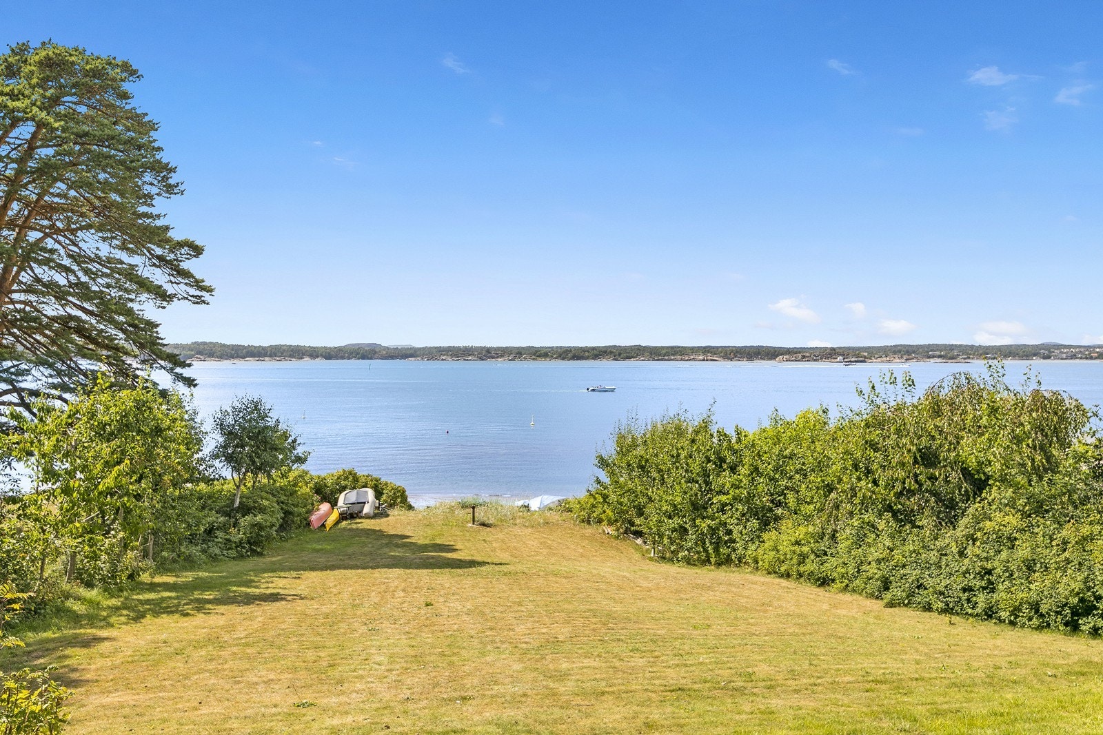 Tomten strekker seg helt ned til sjøen med badestrand. Galleribilde