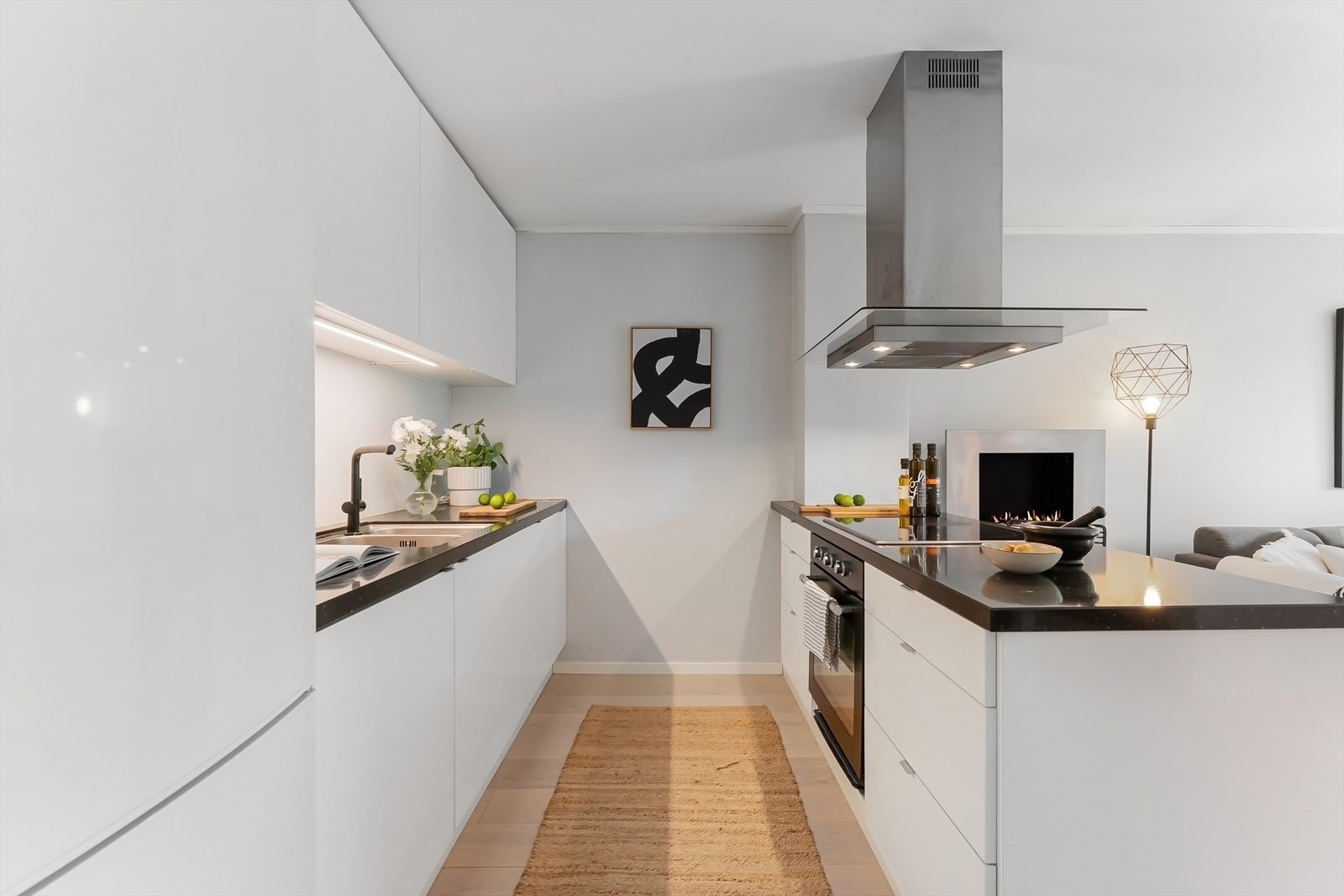 Kjøkkenet har slette fronter, belysning under overskap, fritthengende vifte med kullfilter og integrerte hvitevarer. Automatisk vannstopper er montert. Galleribilde