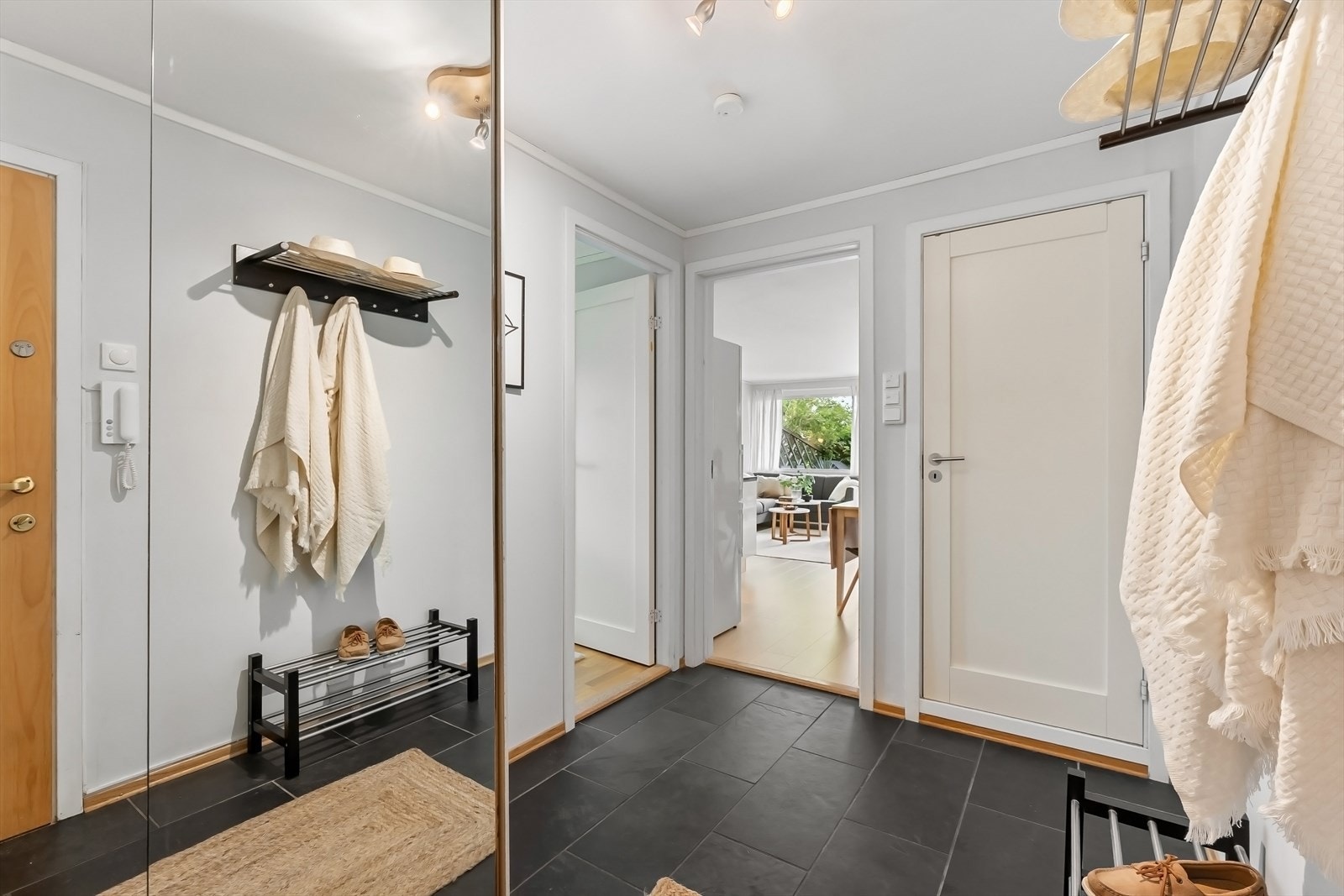 Entré med fliser på gulv og rikelig oppbevaring i skyvedørsgarderobe. God plass til ekstra klesoppheng og skohyller/skoskap. Galleribilde