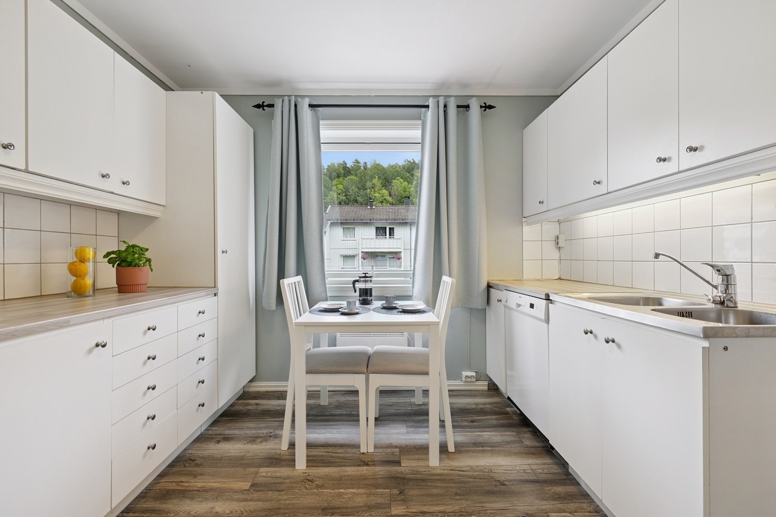 Kjøkkeninnredning med slette lyse fronter og benk i heltre. Galleribilde