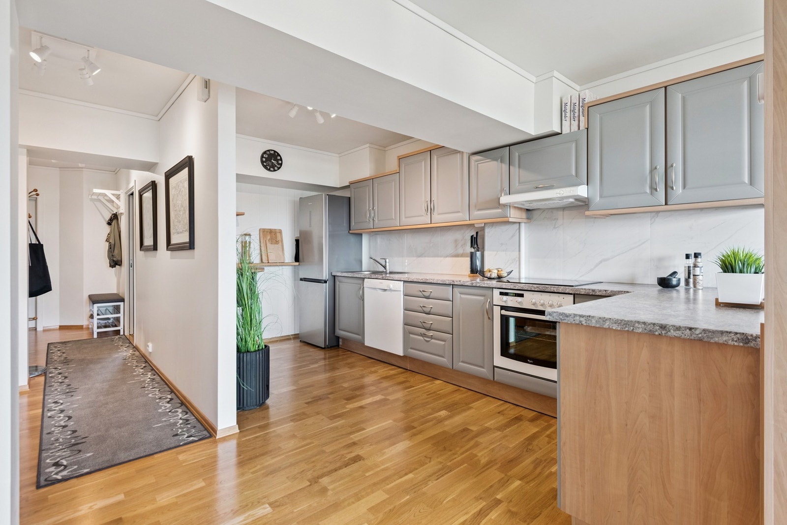 Moderne kjøkken med integrerte hvitevarer og frokostplass. Galleribilde