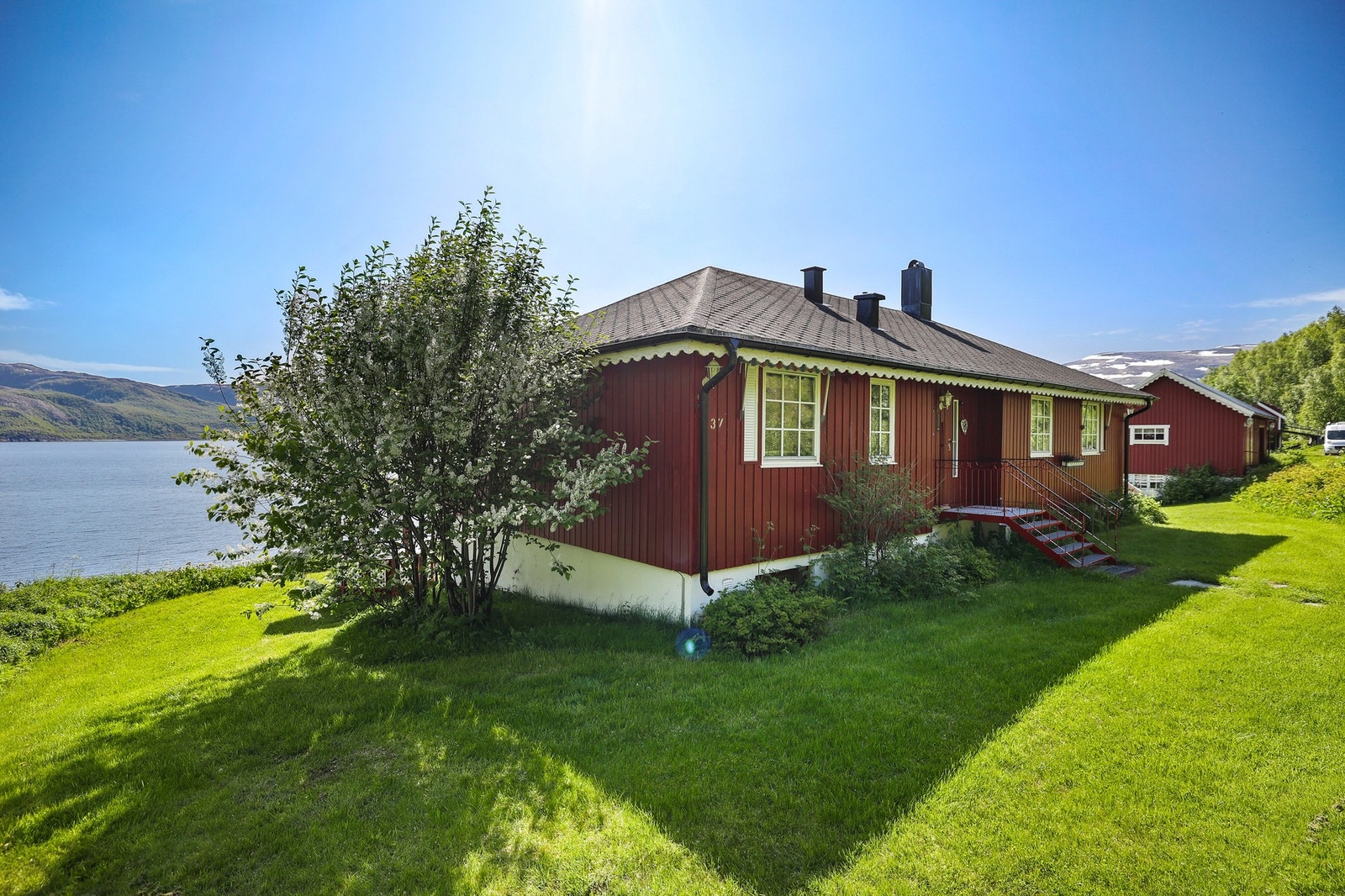 Det er gode utemuligheter på den flotte grønne plenen rundt boligen. Galleribilde