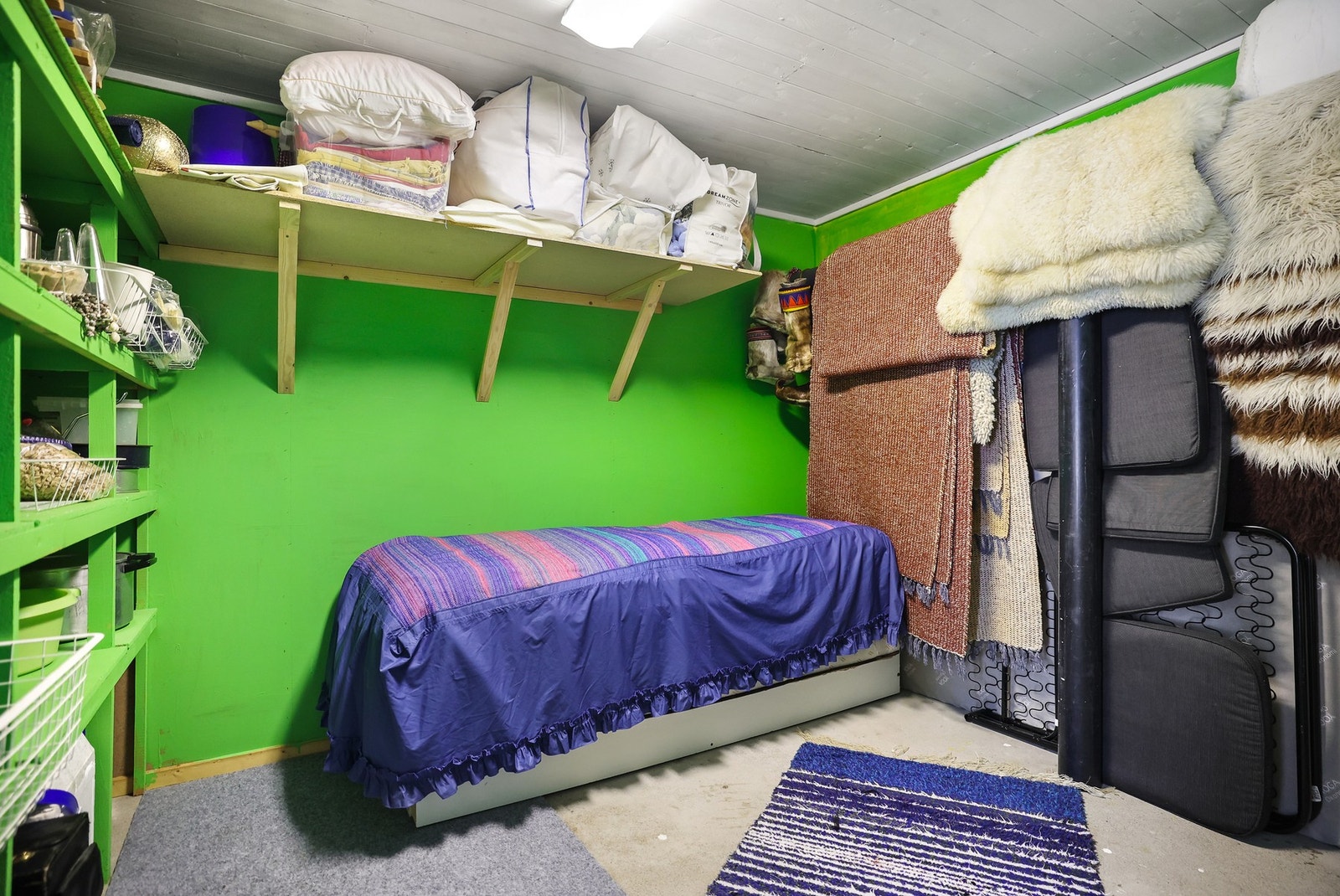 Bod i underetasjen, innredet med praktiske hyller. Galleribilde