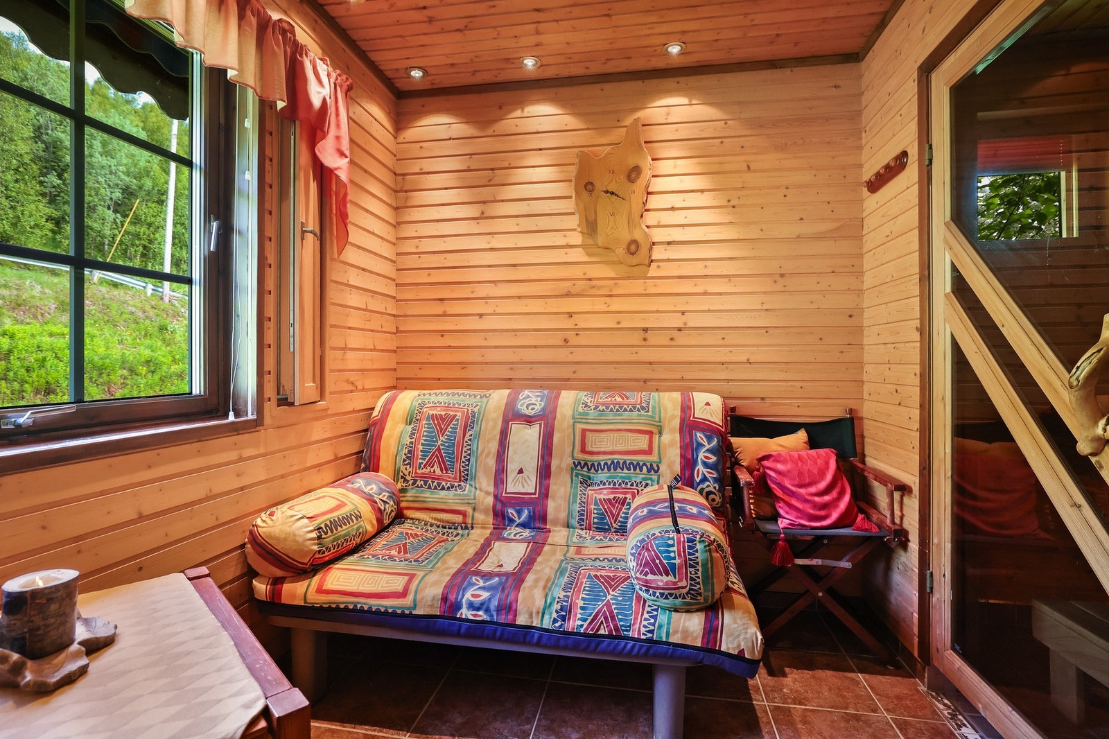 Omkledningsrom i tilknytning til bad og badstue, med heltrepanel, downlights og flislagt gulv. Galleribilde