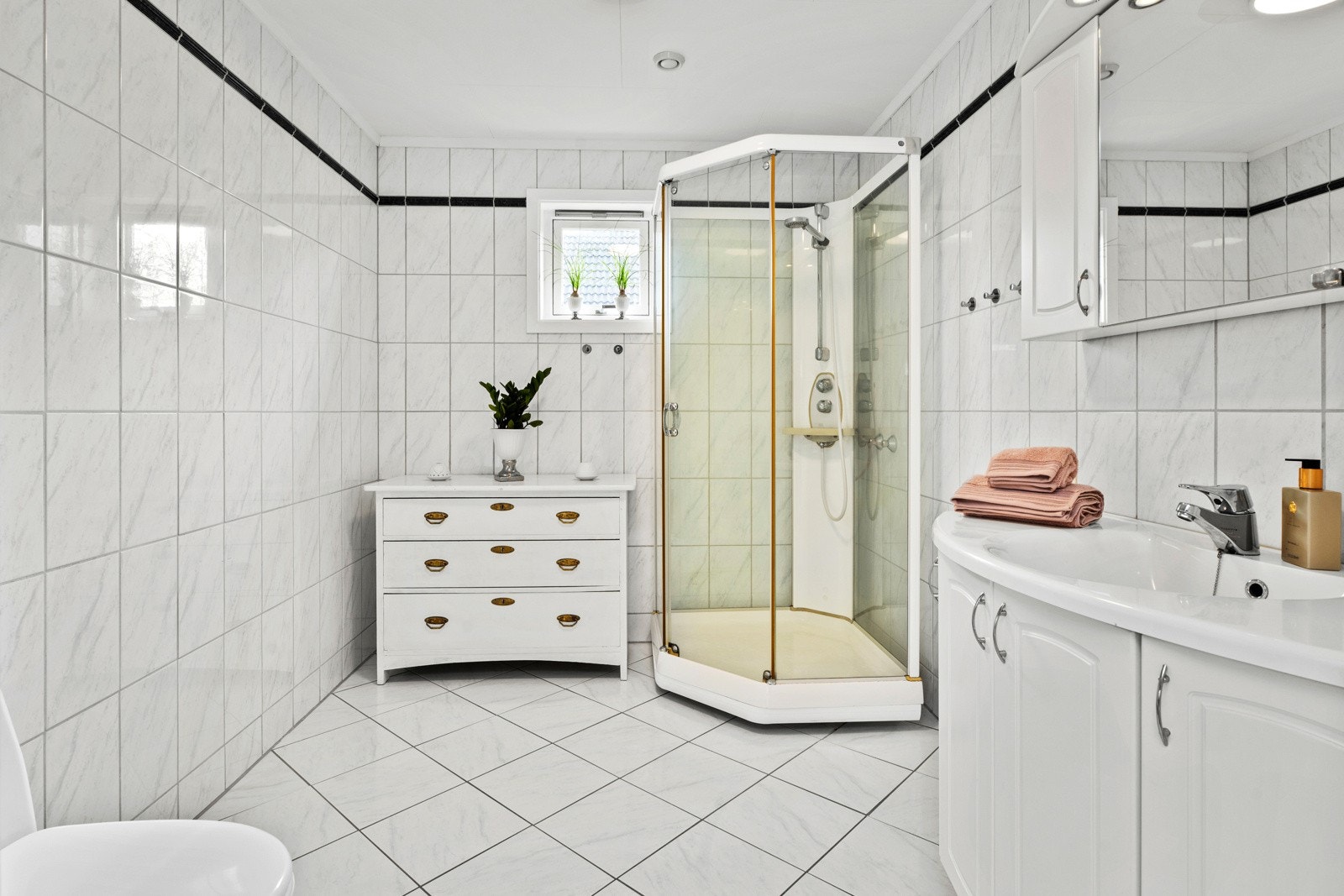 Det har behagelig "barfotvennlig" varme i gulvet og det er lyse, tidløse fliser på både vegger og gulv. Galleribilde