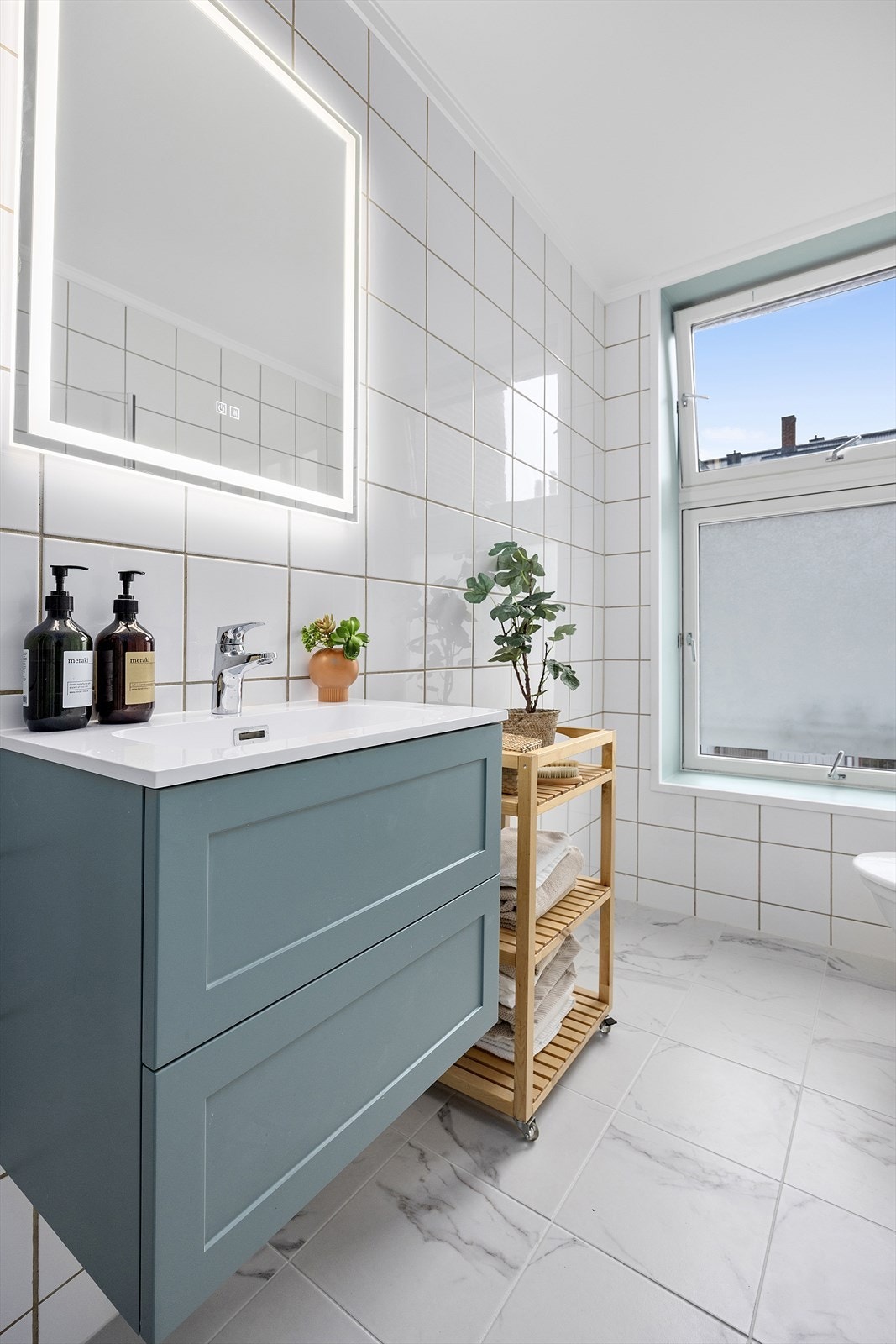 Pent bad med dusj, servant og opplegg for vaskemaskin. Galleribilde