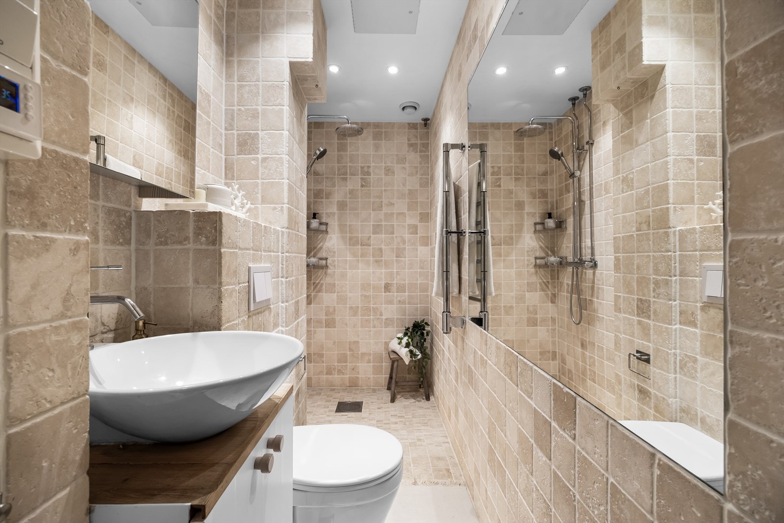 Badet er lyst og innbydende, med servant, varmekabler i gulvet som gir ekstra komfort, og en romslig dusjsone for en avslappende start på dagen. Galleribilde