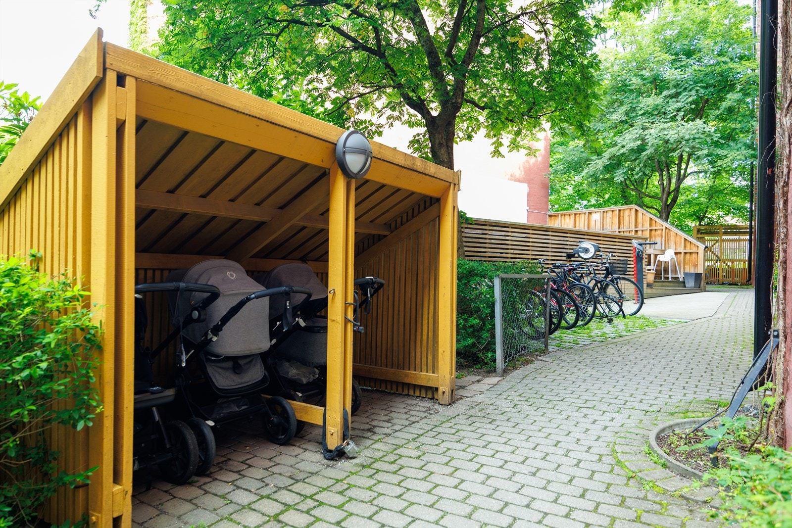 Praktisk skur til barnevogn i bakgården. Galleribilde