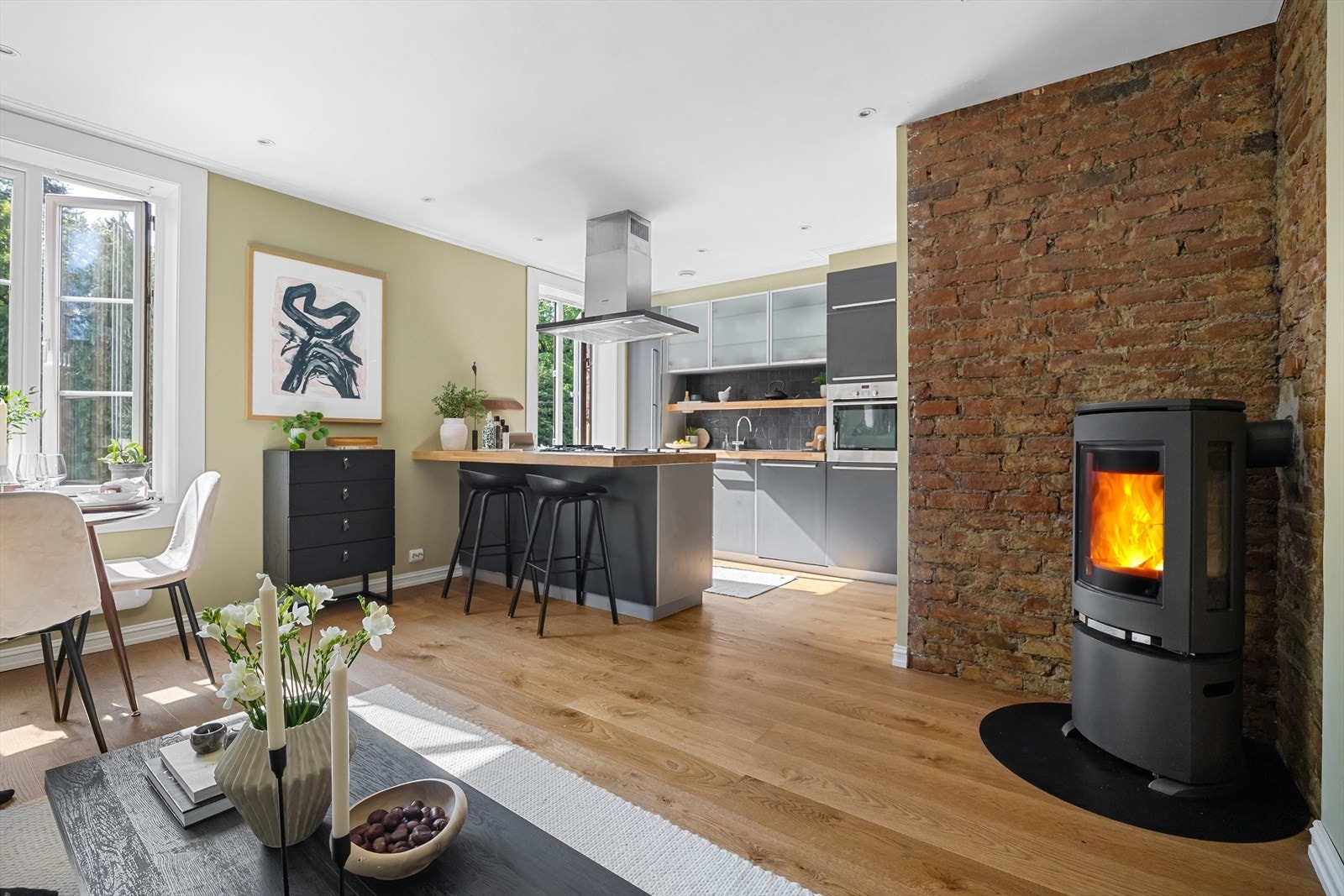 Peishjørnet med åpen teglstein gir en enkel og ekte følelse til rommet. Den rå, røde teglsteinen skaper en fin kontrast til resten av interiøret, og gir en lun og naturlig varme uten å bli for prangende. Galleribilde