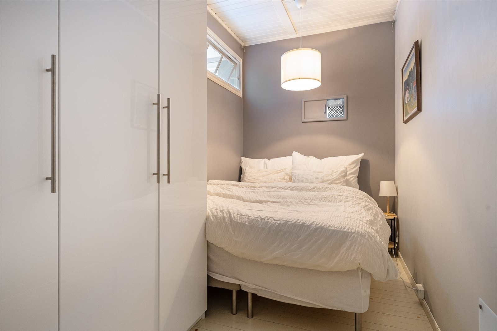 Leiligheten har en praktisk sovealkove med et stort skap som gir mye lagringsplass og et trevindu ut til kjøkkenet. I rommet er det plass til en dobbeltseng og nattbord. Galleribilde