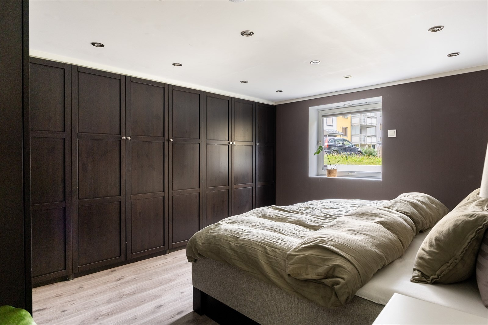 Stort og romslig soverom med plassbygde garderobeskap og downlights i himling Galleribilde