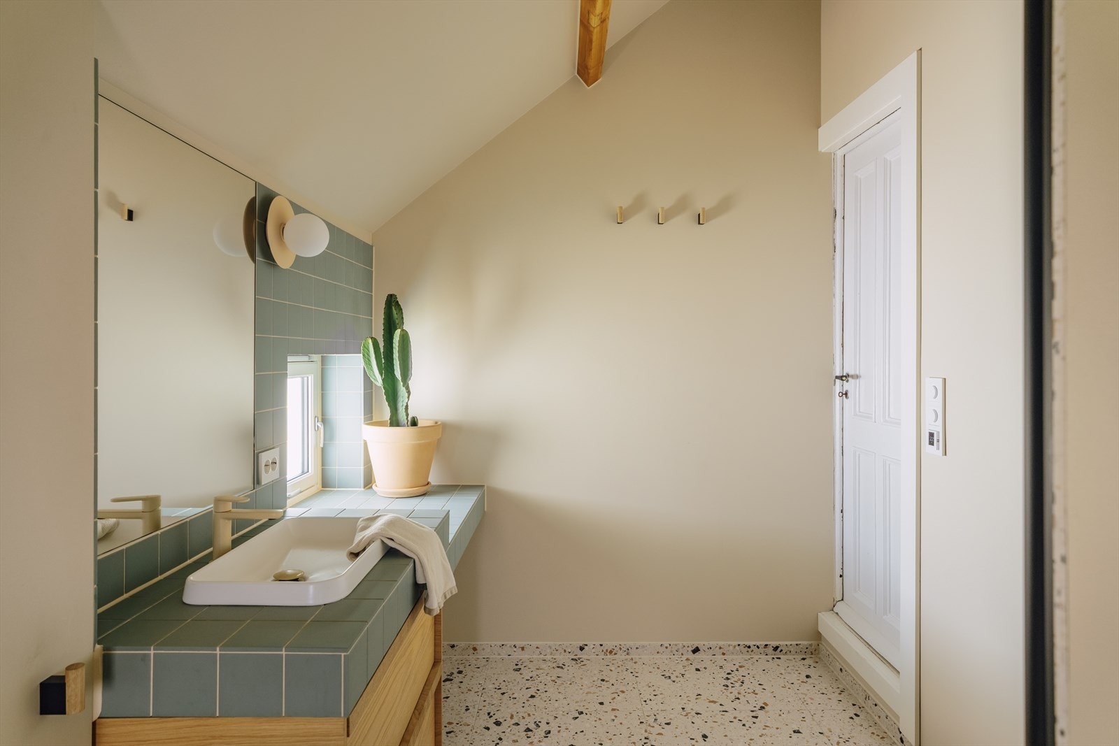 Videre innredet med nedfelt servant i baderomsmøbel, veggmontert toalett og dusjhjørne. Badet har praktisk nisje hvor man har opplegg for vaskemaskin. Galleribilde