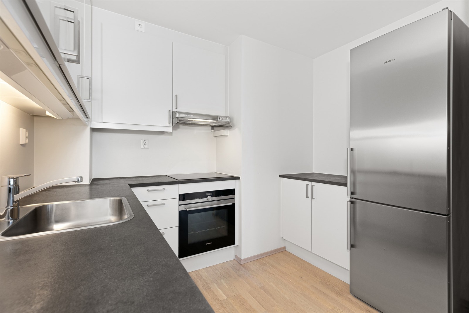 Integrerte hvitevarer som koketopp, stekeovn, oppvaskmaskin og frittstående kjøleskap medfølger Galleribilde