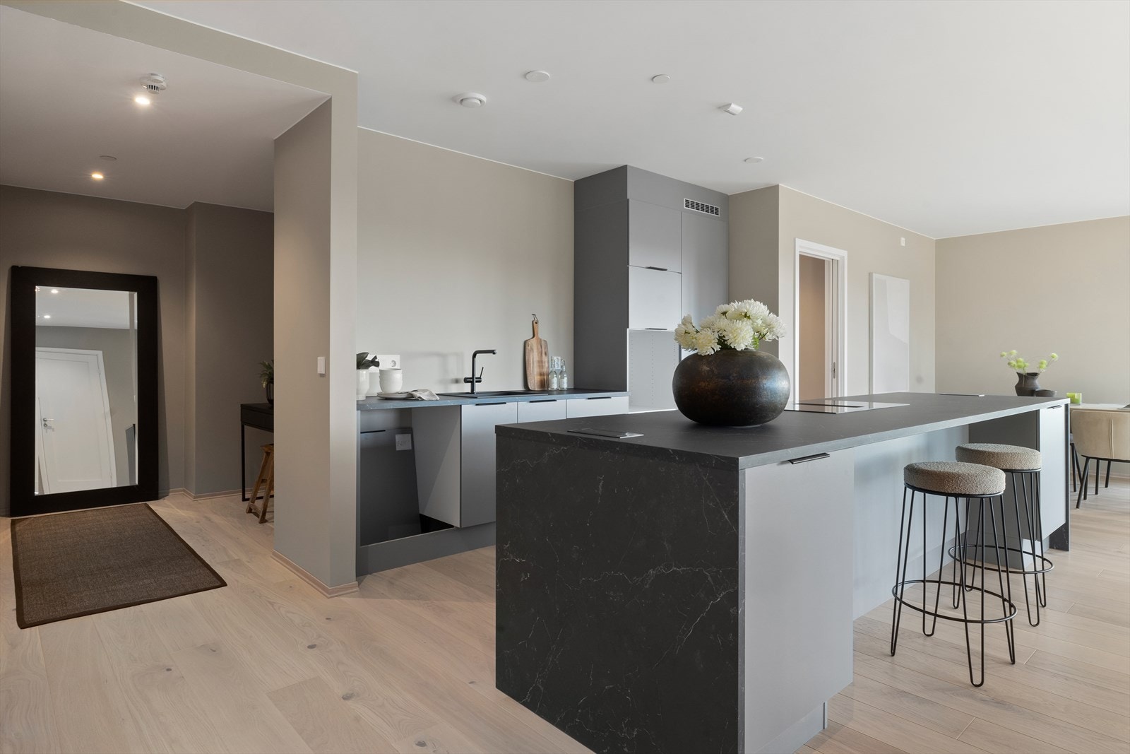 Delikat kjøkkeninnredning i moderne fargevalg med slette skapfronter og romslig kjøkkenøy Galleribilde