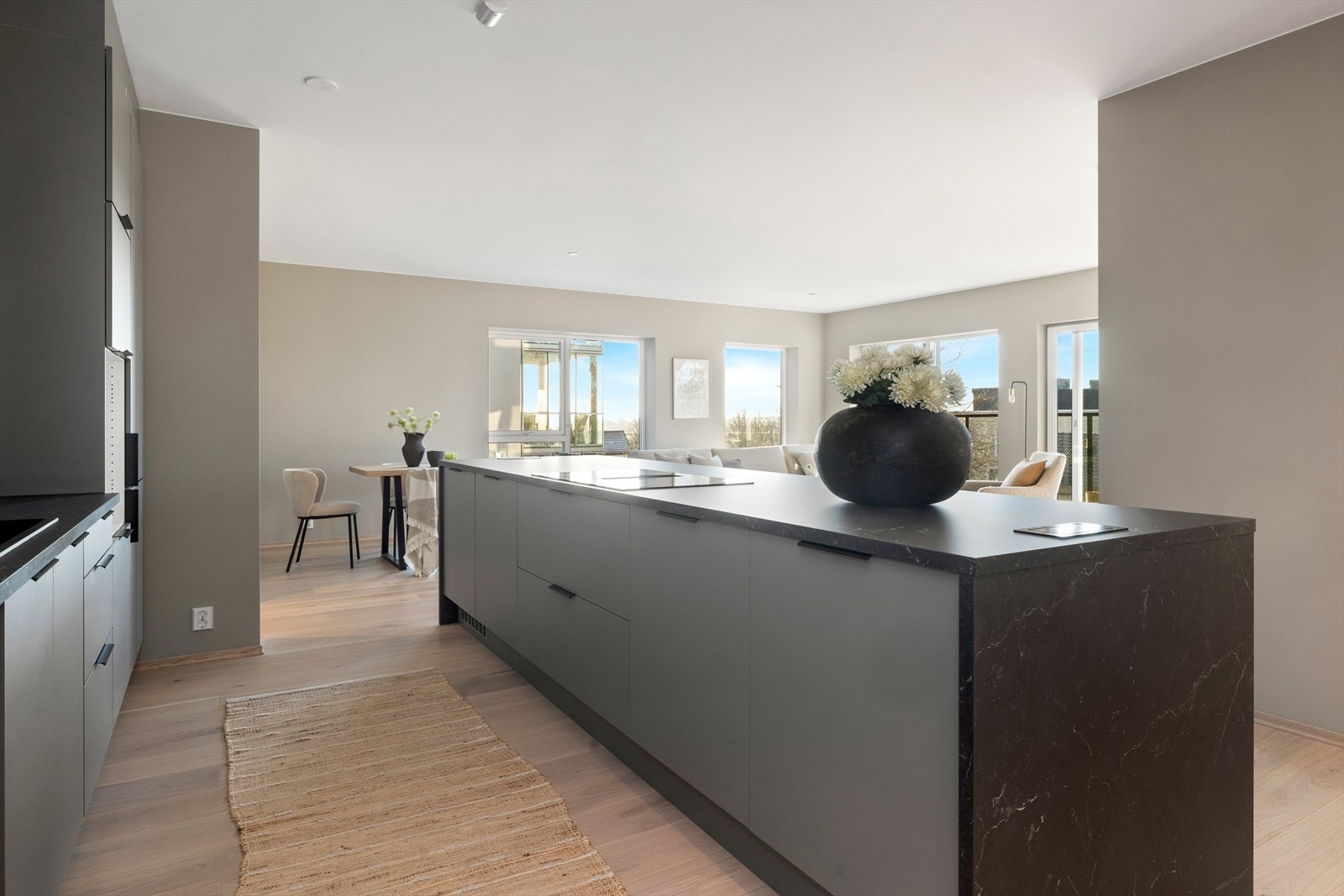 Kjøkken i åpen løsning til stue med en brukervennlig kjøkkenøy hvor du har barbenk Galleribilde