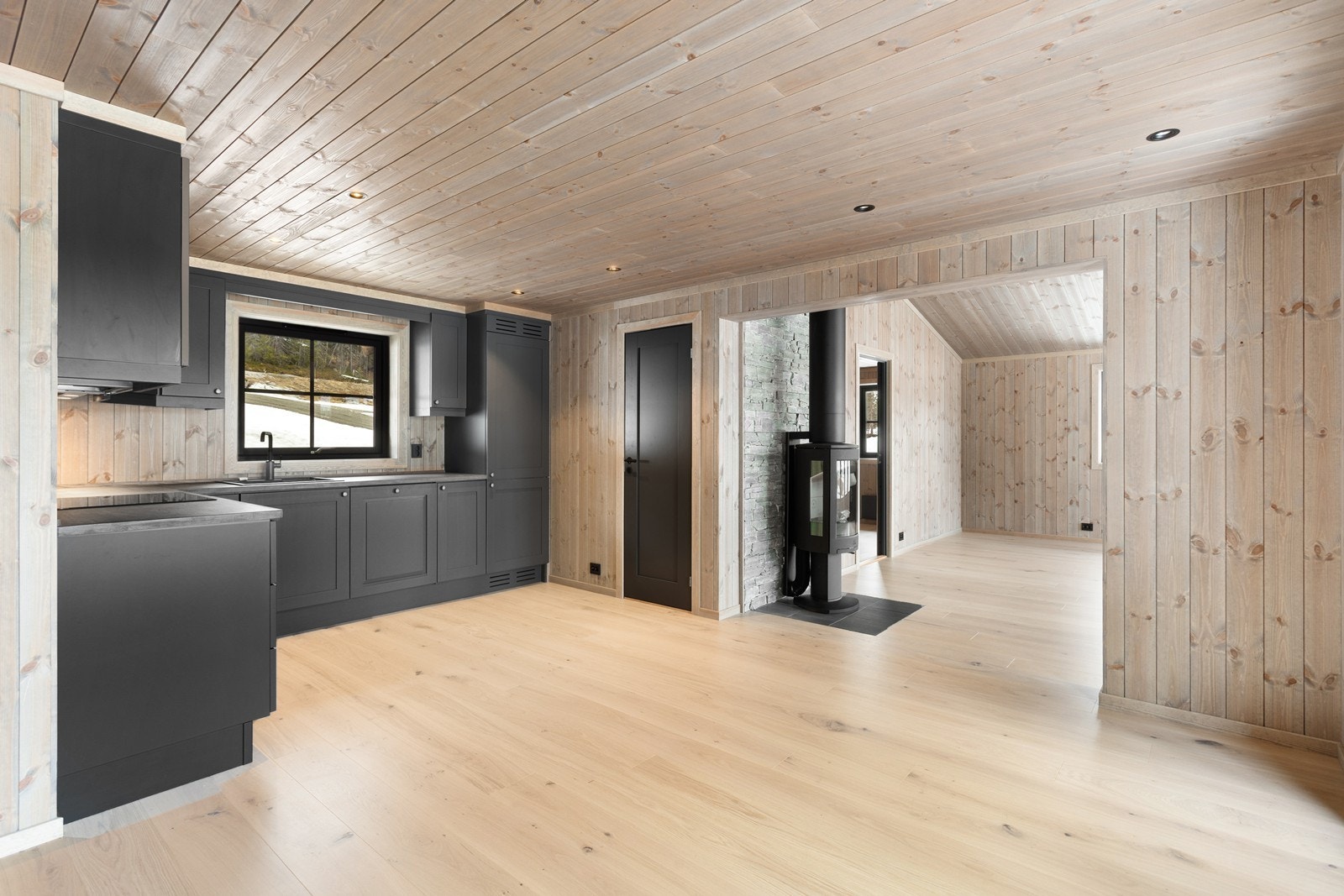 Kjøkkenet er en drøm for matlaging og sosialt samvær, med den tidløse kjøkkeninnredningen fra Nedre Eggedal Hyttemøbel, malt i en lekker gråfarge. Galleribilde