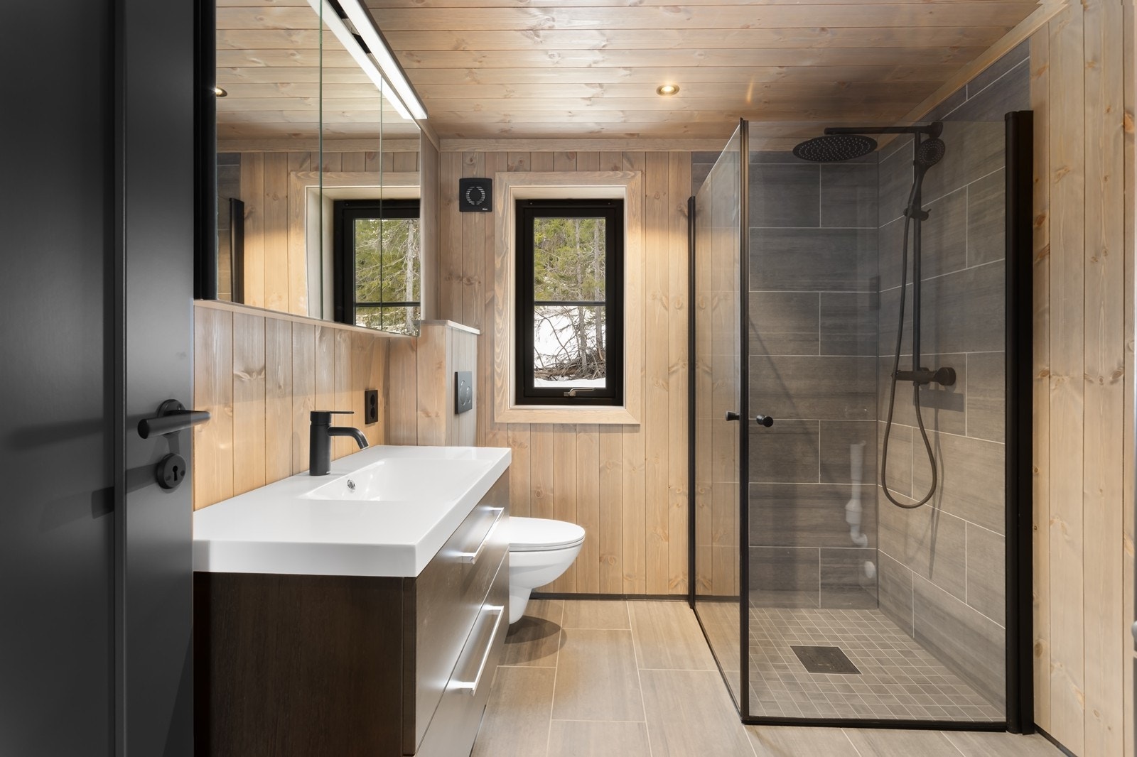 Lekkert hovedbad med innredning med heldekkende servant, speilskap, toalett og dusjhjørne. Galleribilde