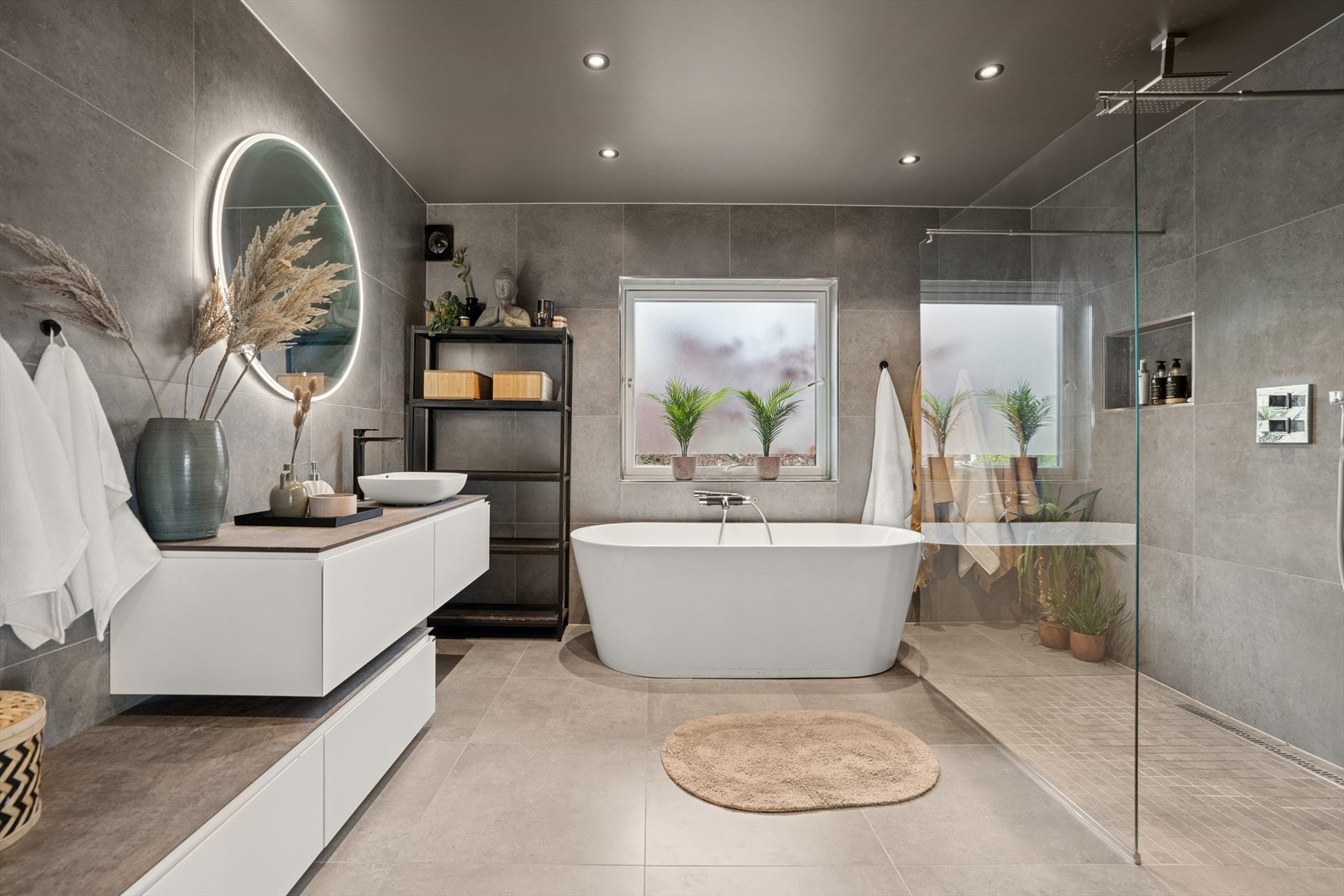 Delikat baderomsinnredning med finer/folie fronter, kompositt benkeplate og speil. Lekkert badekar og stort dusjhjørne/nisje med glassvegg. Galleribilde