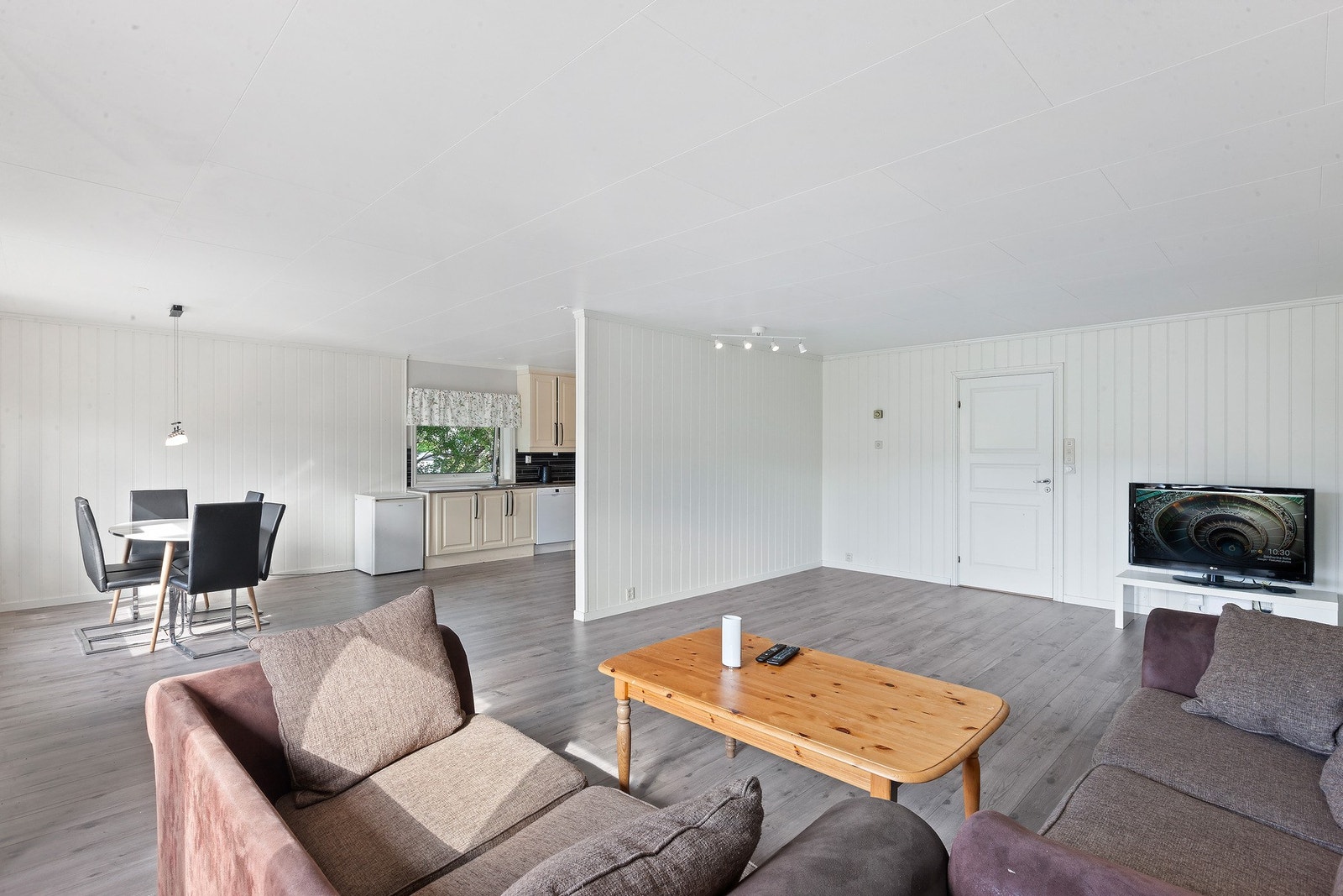 Stue og kjøkken ligger i en delvis åpen løsning Galleribilde