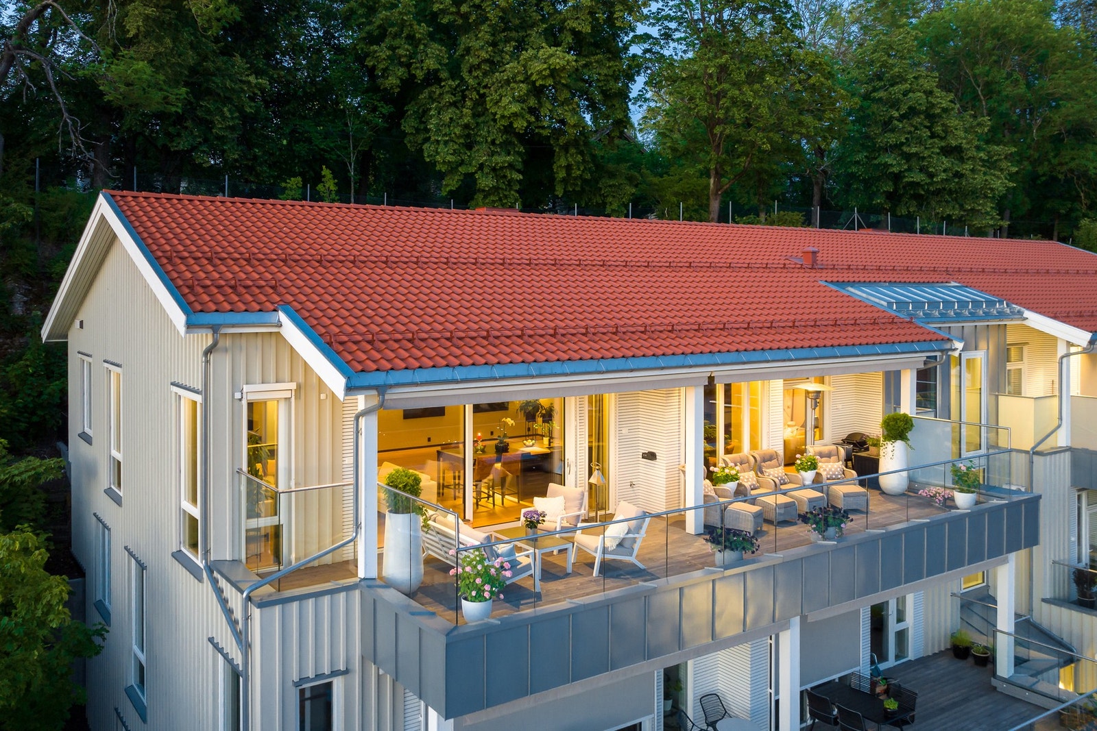 Fasadebilde med lekker terrasse, her er det impregnerte gulvbord og rekkverk i laminert glass Galleribilde