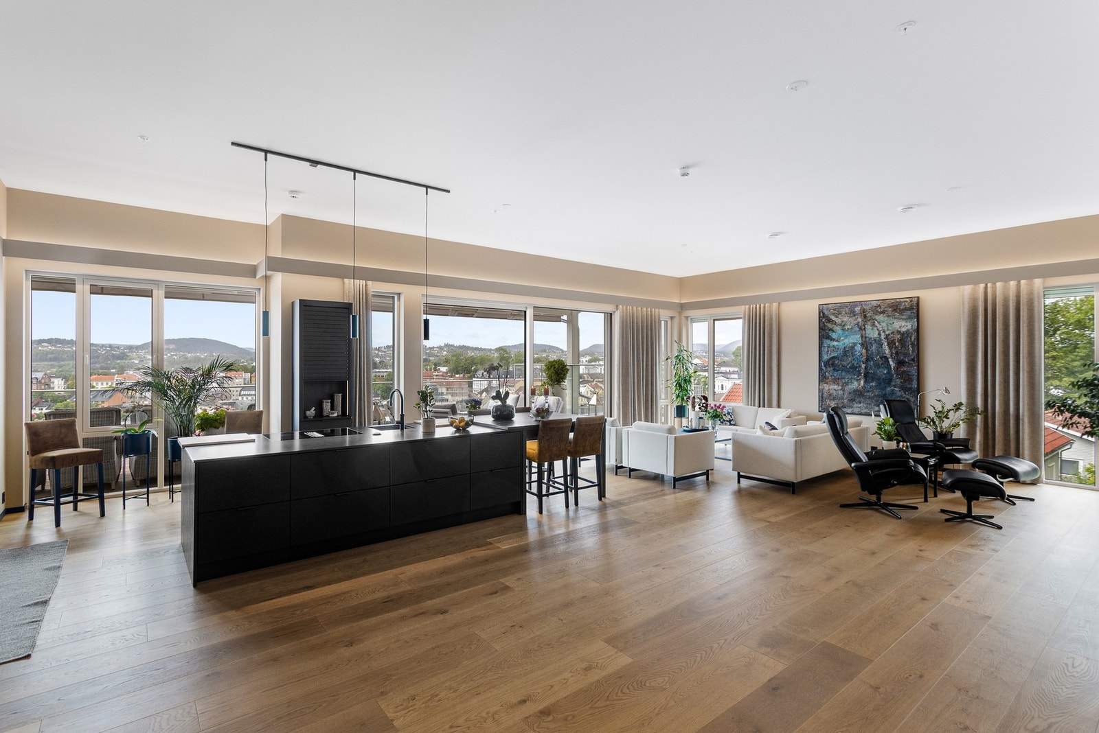 Romslig stue, her er det lagt eike-parkett på gulv og sorte lister som gir en fin kontrast Galleribilde