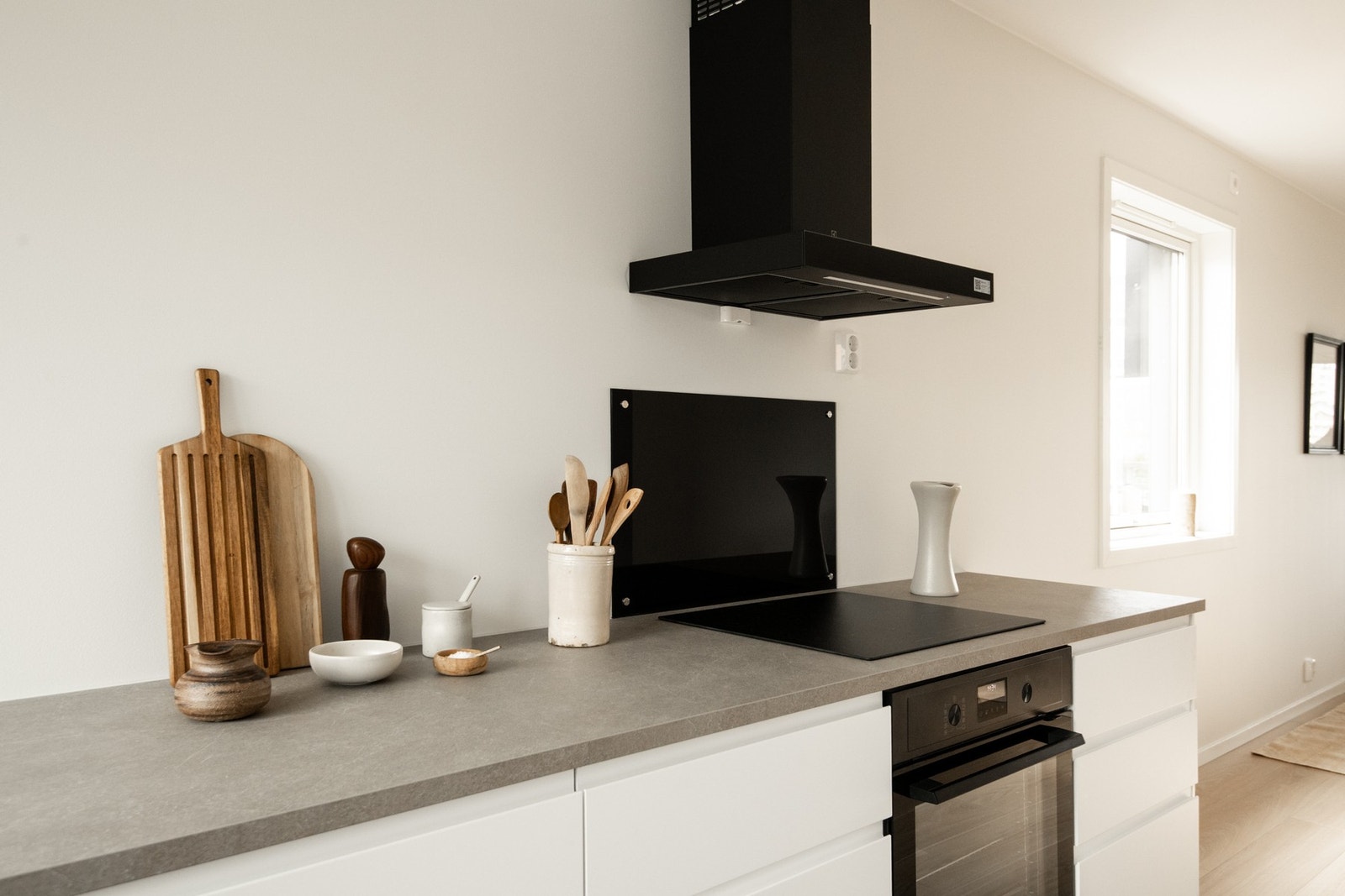 Den delvis åpne løsningen mot stuen skaper en sosial og luftig sone, samtidig som selve kjøkkenet gir en effektiv arbeidsflyt for matlaging. Galleribilde