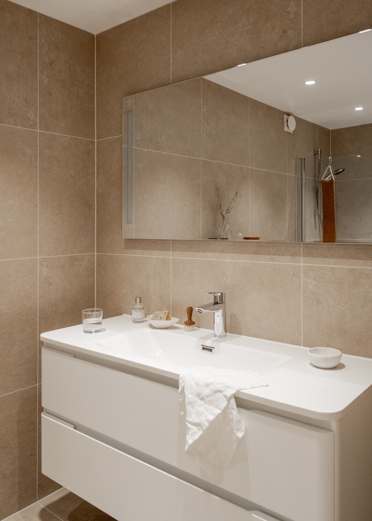 Badet er pent innredet med et vegghengt servantskap med to romslige skuffer og en ovenpåliggende servant. Galleribilde