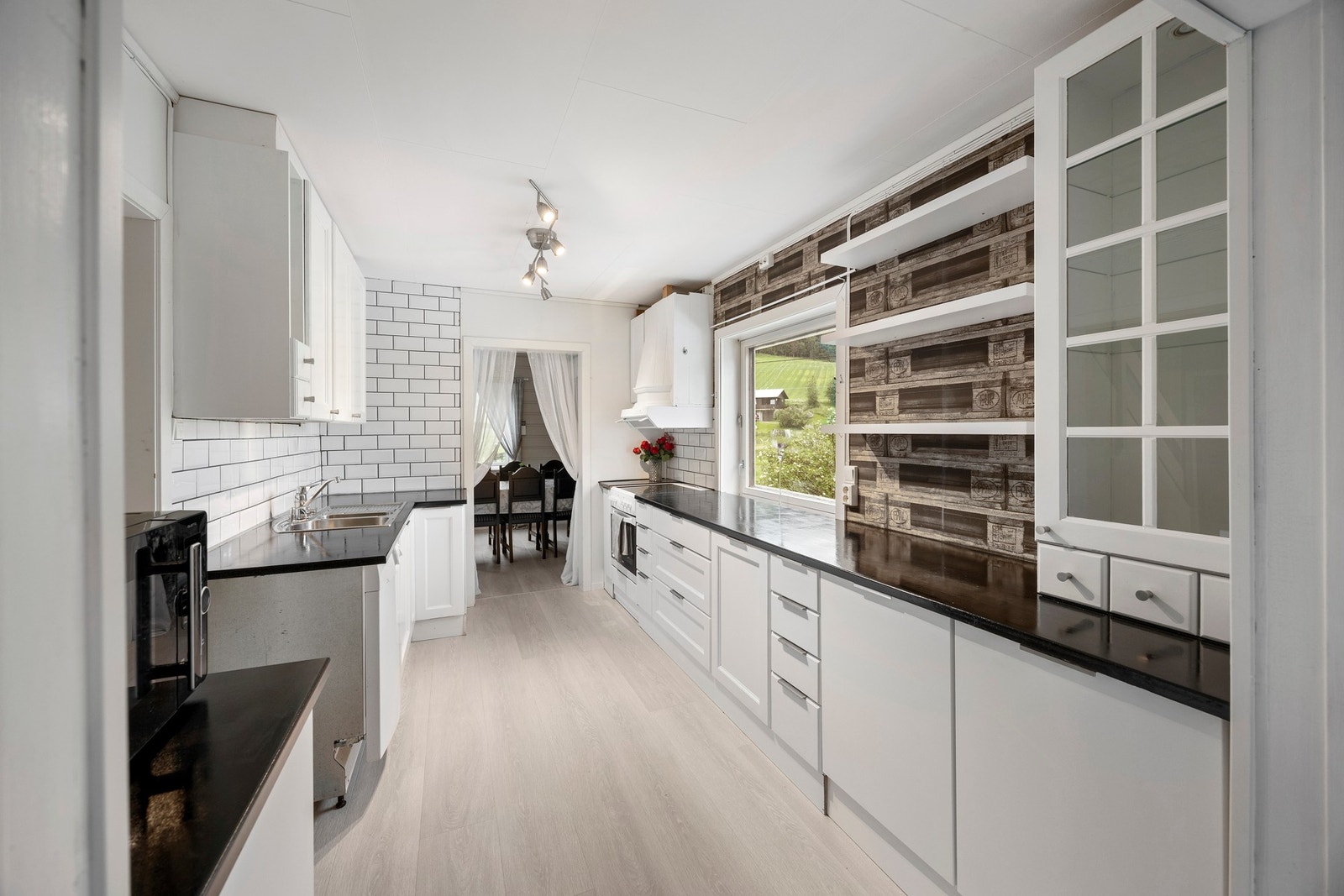 Lys og tidløs kjøkkeninnredning med mye skap- og benkeplass. Galleribilde