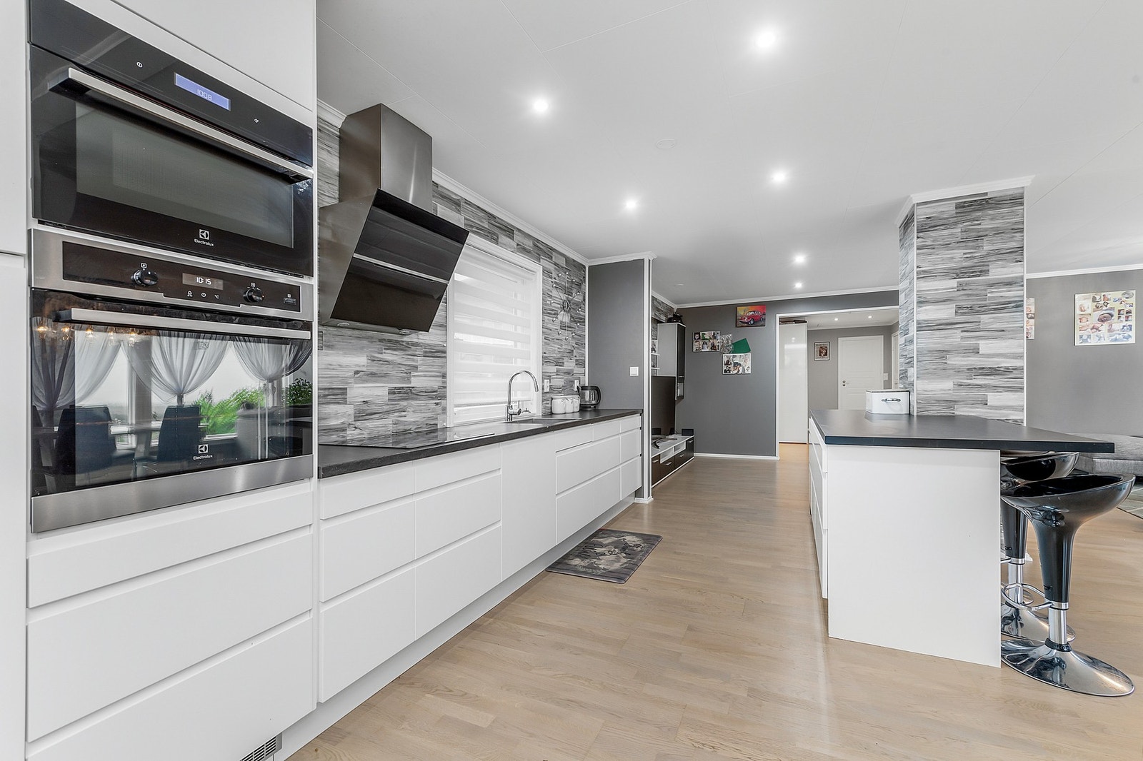 Kjøkkeninnredningen har glatte fronter med laminert
benkeplate. Integrert stekeovn (2 stk), koketopp, oppvaskmaskin,
fryseskap og kjøleskap Galleribilde