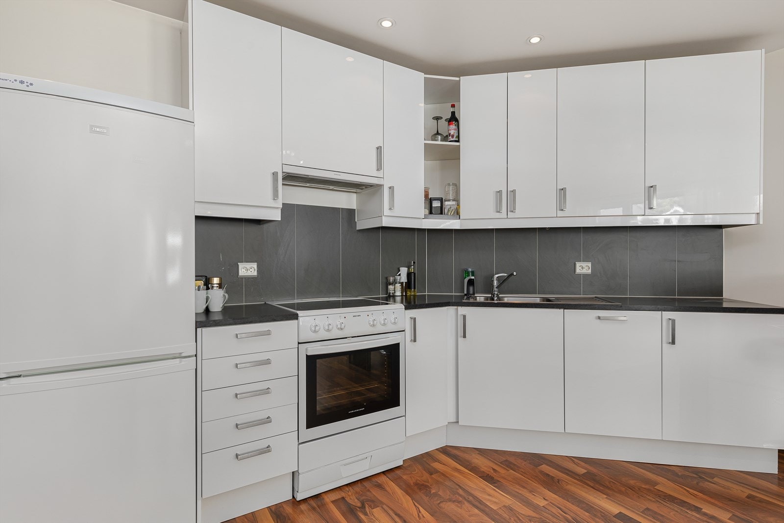 Lekkert og nøytralt kjøkken fra Ikea med kvite glatte frontar, laminert benkeplate og intregert oppvaskmaskin Galleribilde