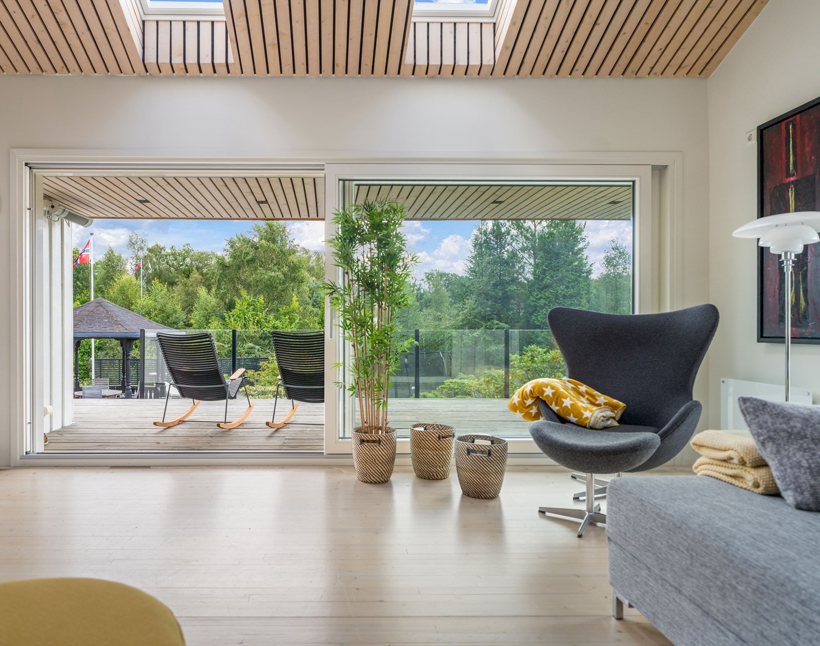 Den gigantiske skyvedøren på 4.5 meter i bredde som åpner opp til en idyllisk hage, balkong og fantastisk utsikt - som gir en sømløs overgang mellom inne- og uterom Galleribilde