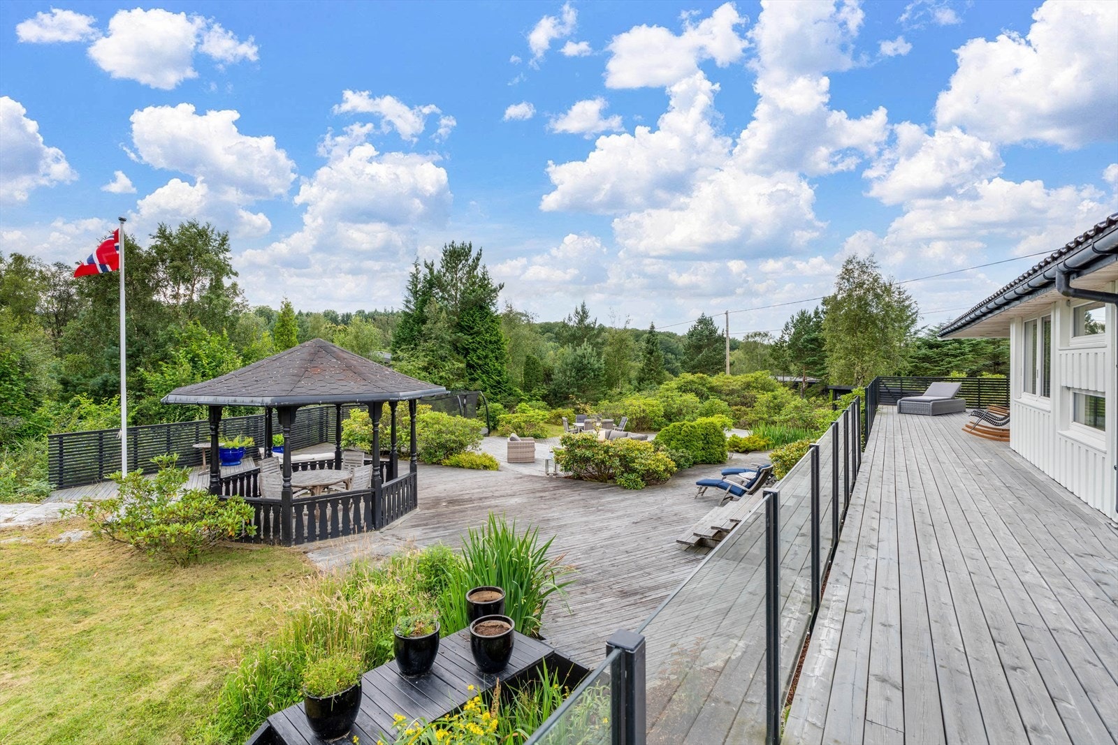 Med terrasser i ulike nivåer og flere soner, byr hagen på muligheten til å finne ditt eget sted for å nyte sommeren og solen - enten du søker fred og ro eller sosialt samvær Galleribilde