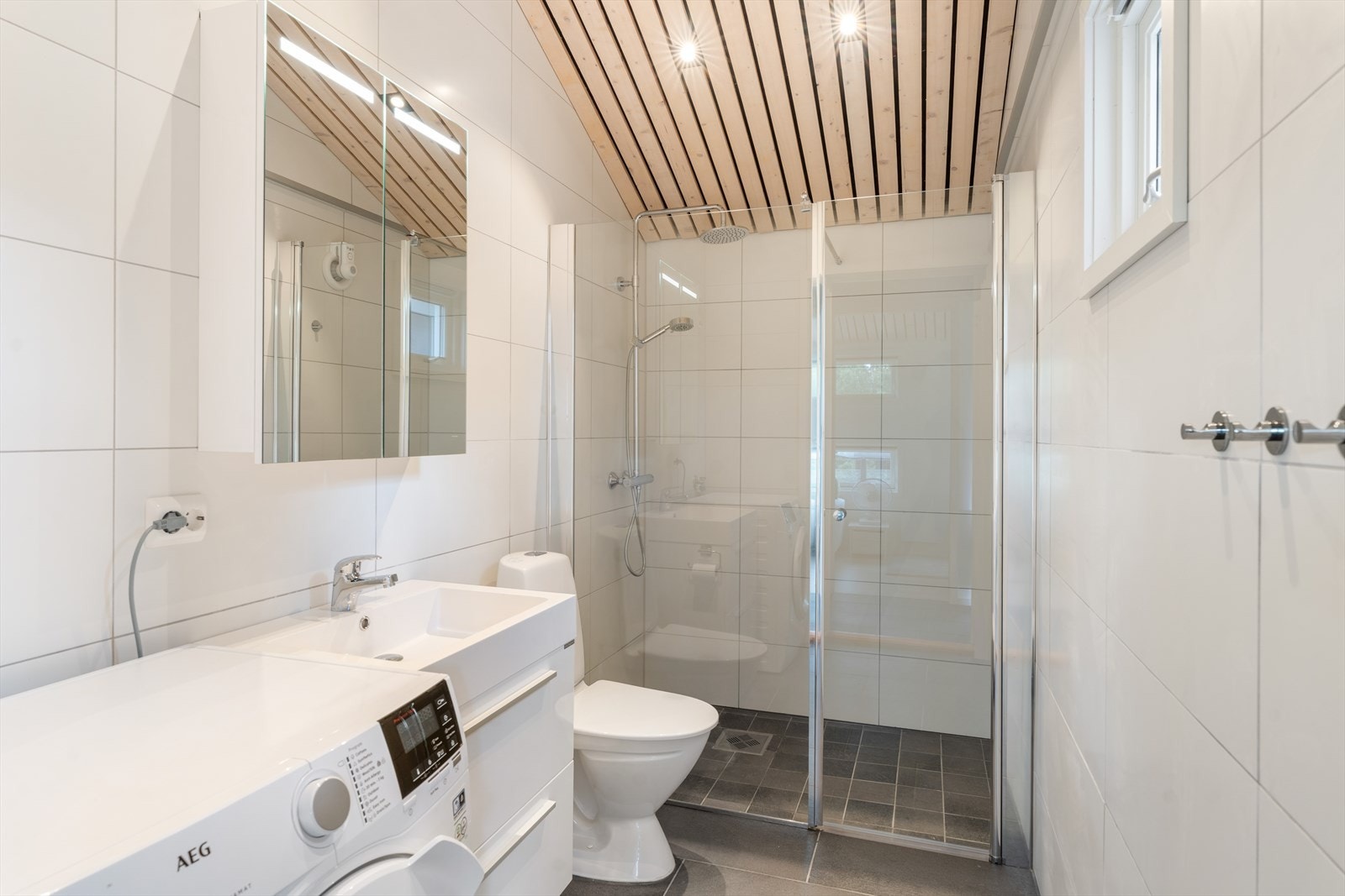 Flott og moderne Bad - Perfekt sted å starte dagen: Badet er en harmonisk kombinasjon av funksjonalitet og eleganse. Med spiler og diskrete spotter i taket skapes en lun og eksklusiv atmosfære Galleribilde