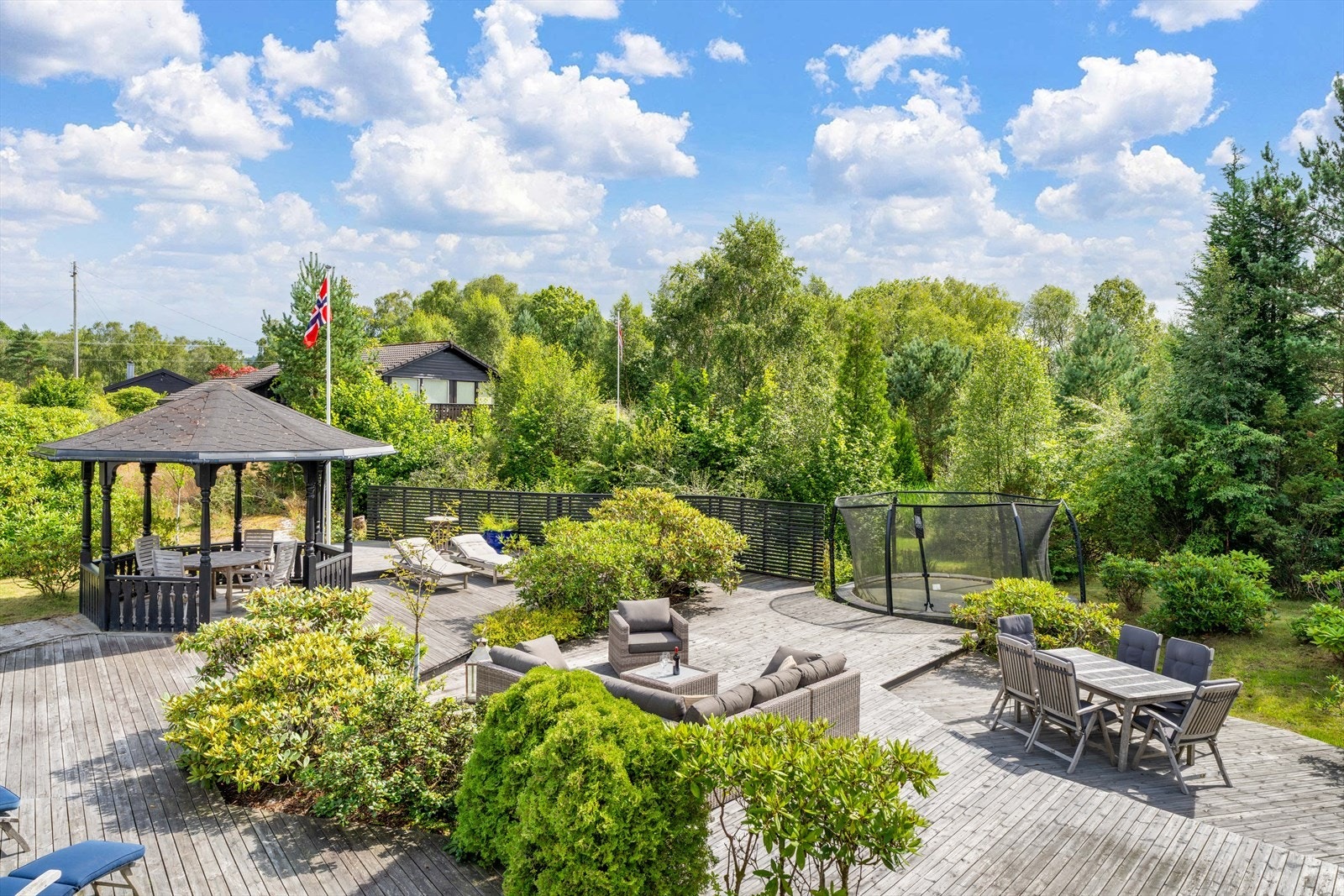 Romslig uteområde med flott terrasse, paviljong, og trampoline. Perfekt for avslapning og underholdning. Ligger i naturskjønne omgivelser Galleribilde