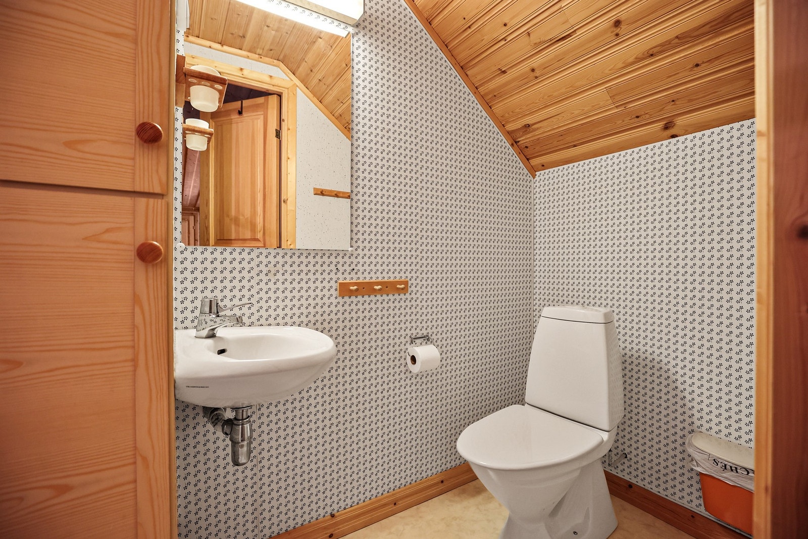 Badet er simpelt med vask, speil og toalett Galleribilde