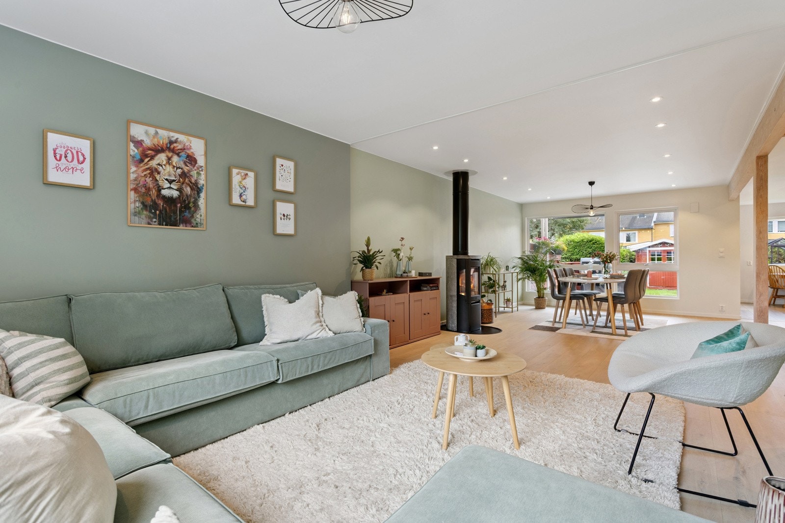 Lys og gjennomgående stue med plass til stor sofa og stort spisebord. En flott peisovn mitt i stuen. Downlights. Galleribilde