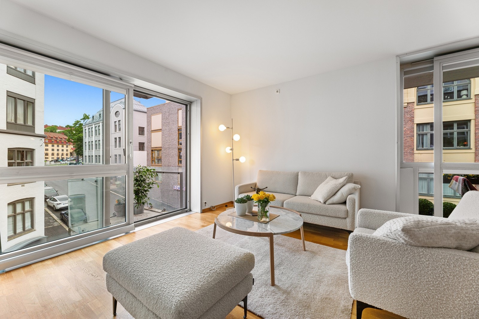 Stuen har god takhøyde og fylles med dagslys fra to sider, via store, påkostede skyvedører med aluminiumsramme og utgang til hver sin balkong. Den luftige følelsen understrekes av lysmalte, glatte veggflater og stilren, listefri himling. Galleribilde