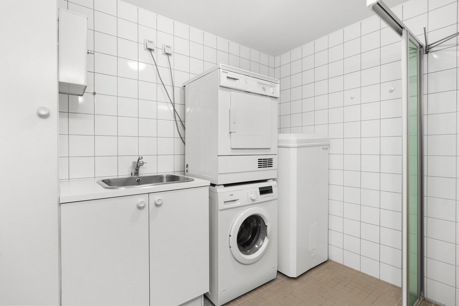 Badet har god plass til vaskemaskin og tørketrommel. Her står også varmtvannsberederen Galleribilde