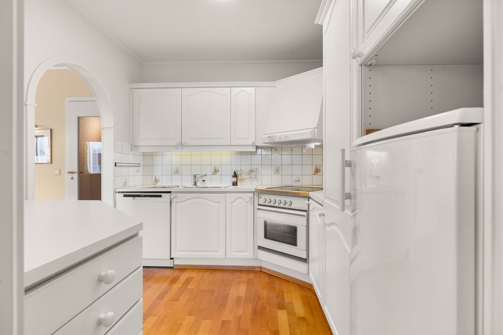 Kjøkkeninnredning med fliser og belysning over benken Galleribilde