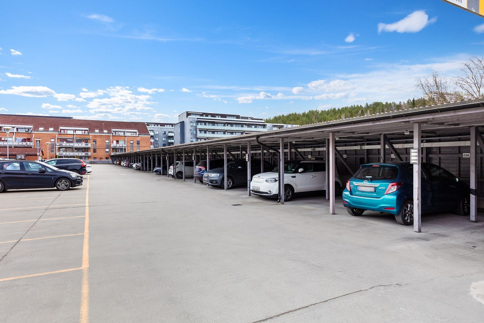 Det følger parkeringsplass i carport med elbillader. Til venstre i bildet er det oppmerket gjesteparkering Galleribilde