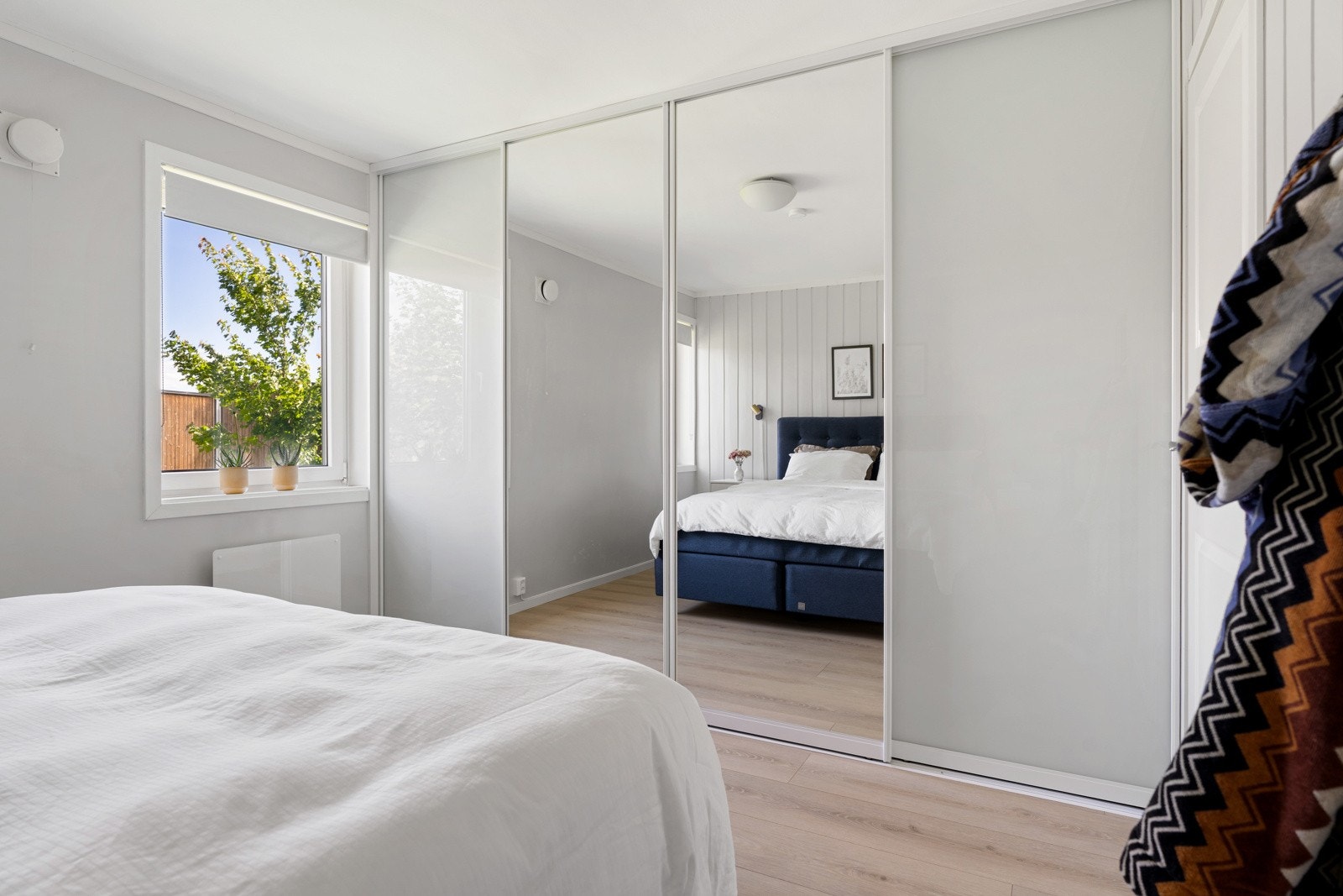 Hovedsoverommet har god lagringsplass i en romslig skyvedørsgarderobe fra Opas Garderobe. Galleribilde