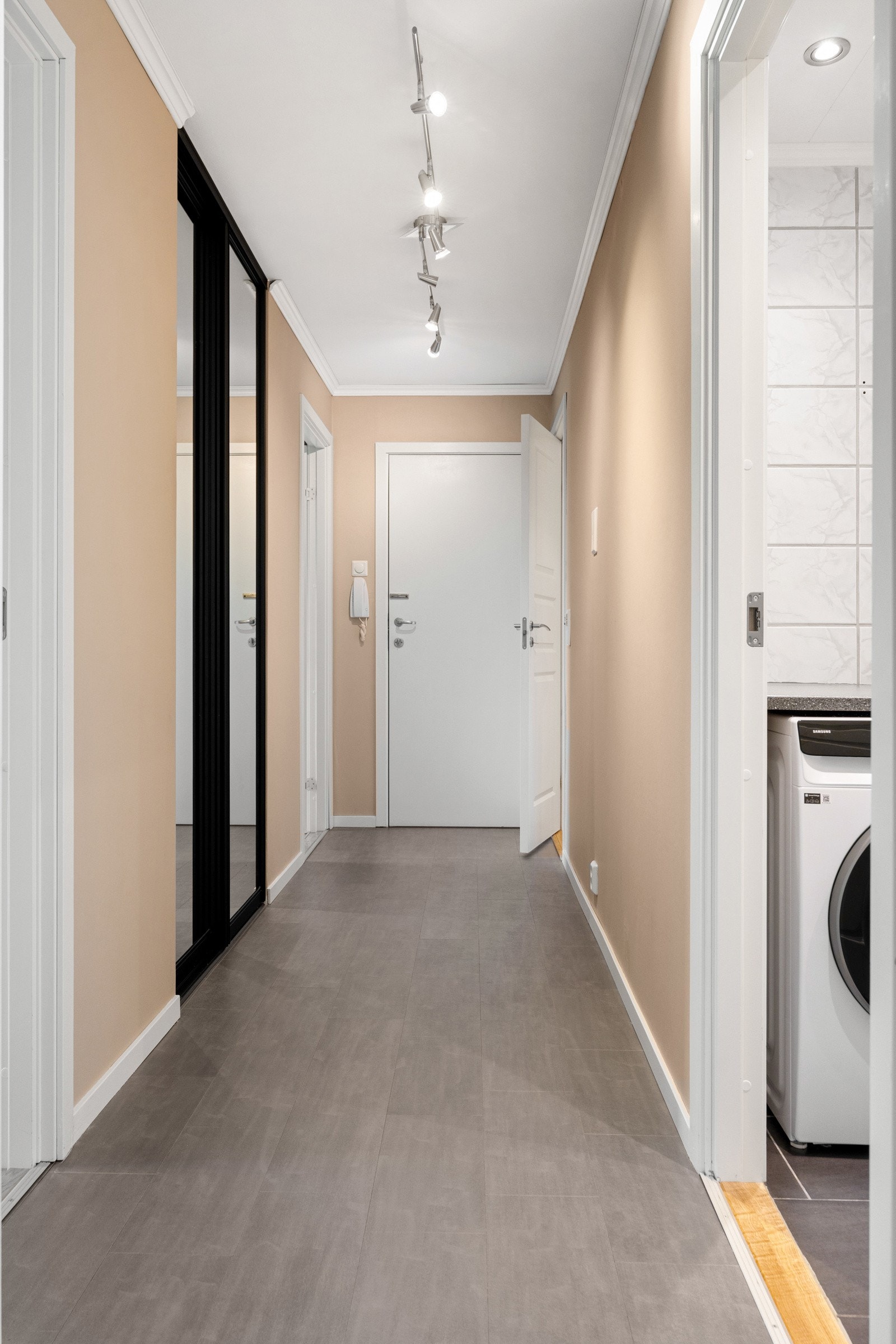 Man kommer inn i leiligheten via en romslig entré med behagelig gulvvarme. Her er det er god plass til oppbevaring av klær og sko. Gangen er utstyrt med en praktisk skyvedørsgarderobe fra Opas Garderobe. Galleribilde