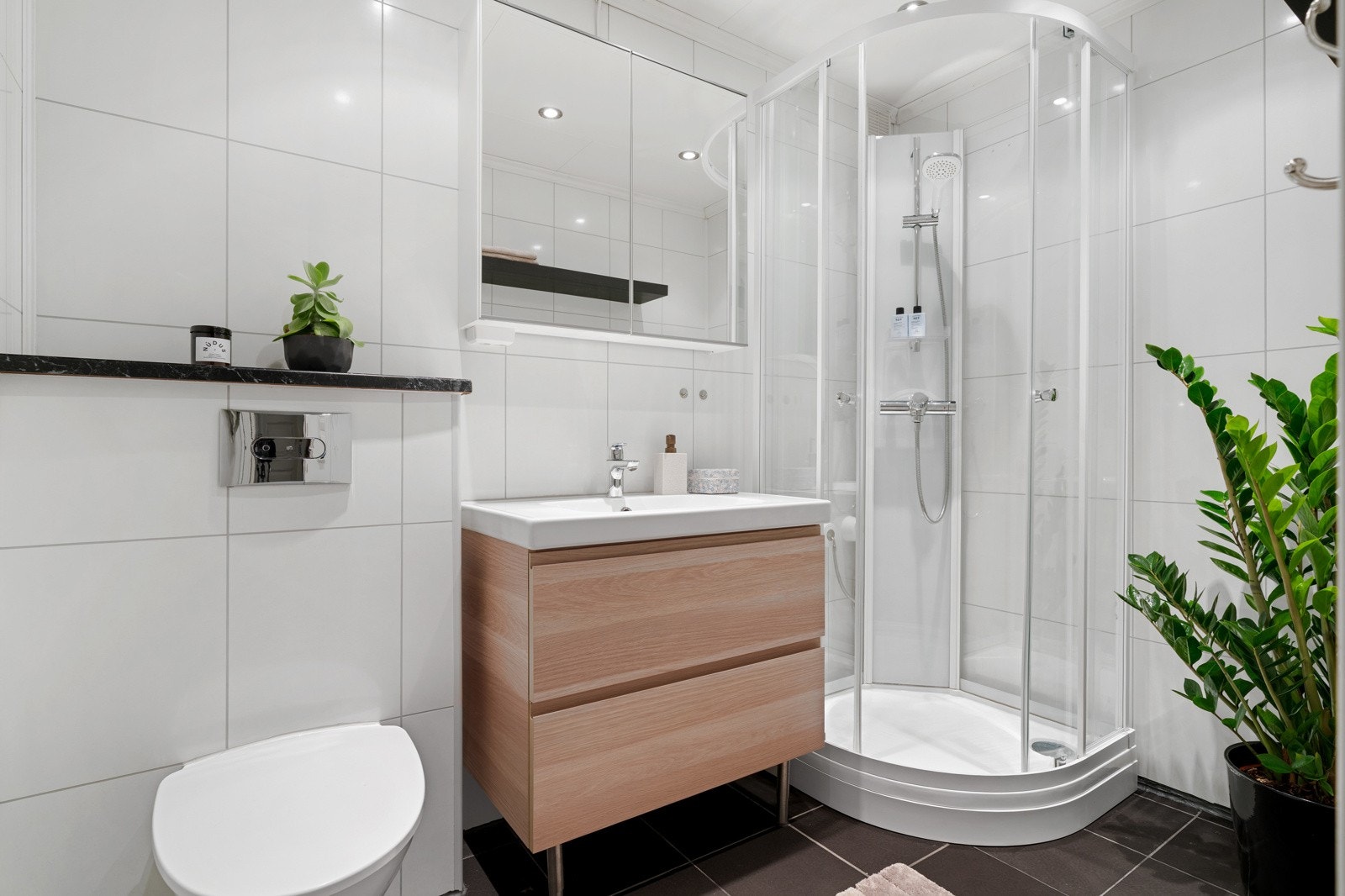 Badet ligger i tilknytning til gangen. Badet har flislagt gulv med varmekabler, våtromsplater på vegg og spotter i himling. Galleribilde