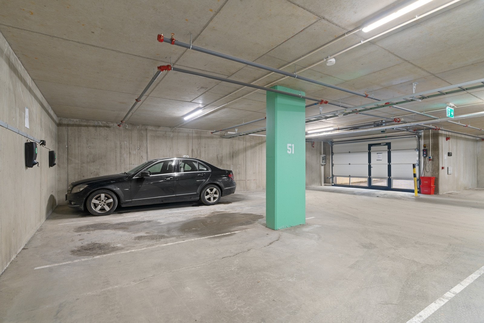 Andelen disponerer egen parkeringsplass like innenfor garasjeporten med ladeboks for elbil Galleribilde