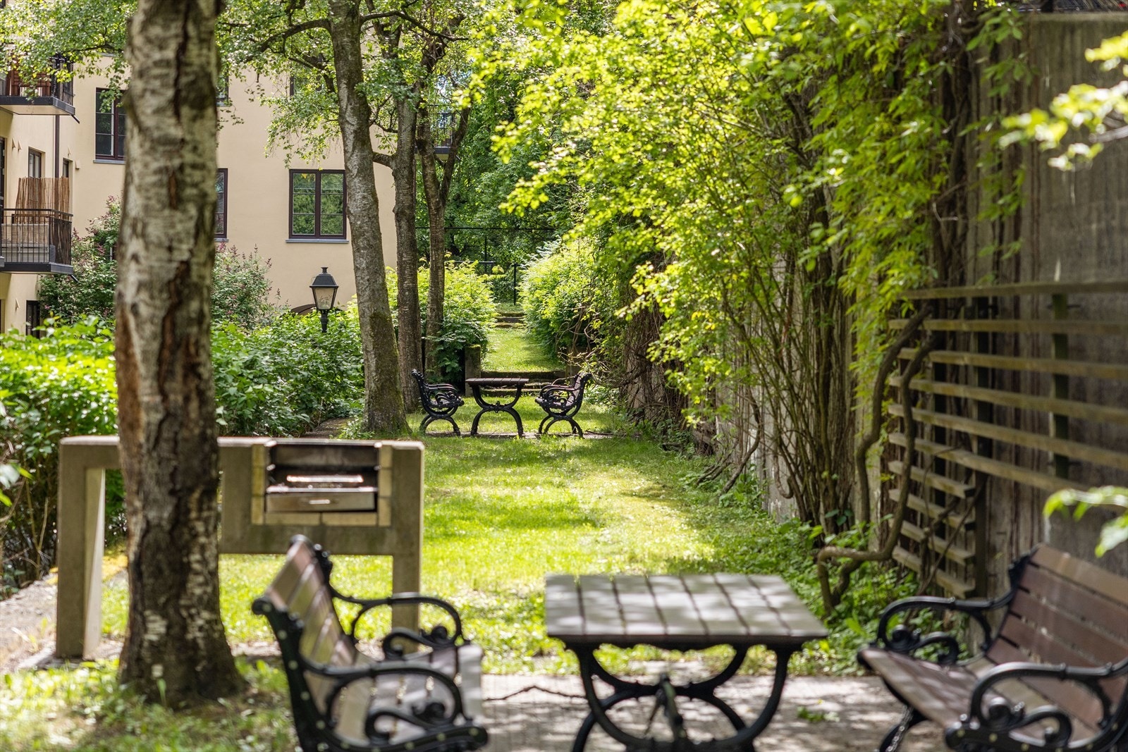 Skjermet, solrik og pent opparbeidet bakgård med sittebenker Galleribilde